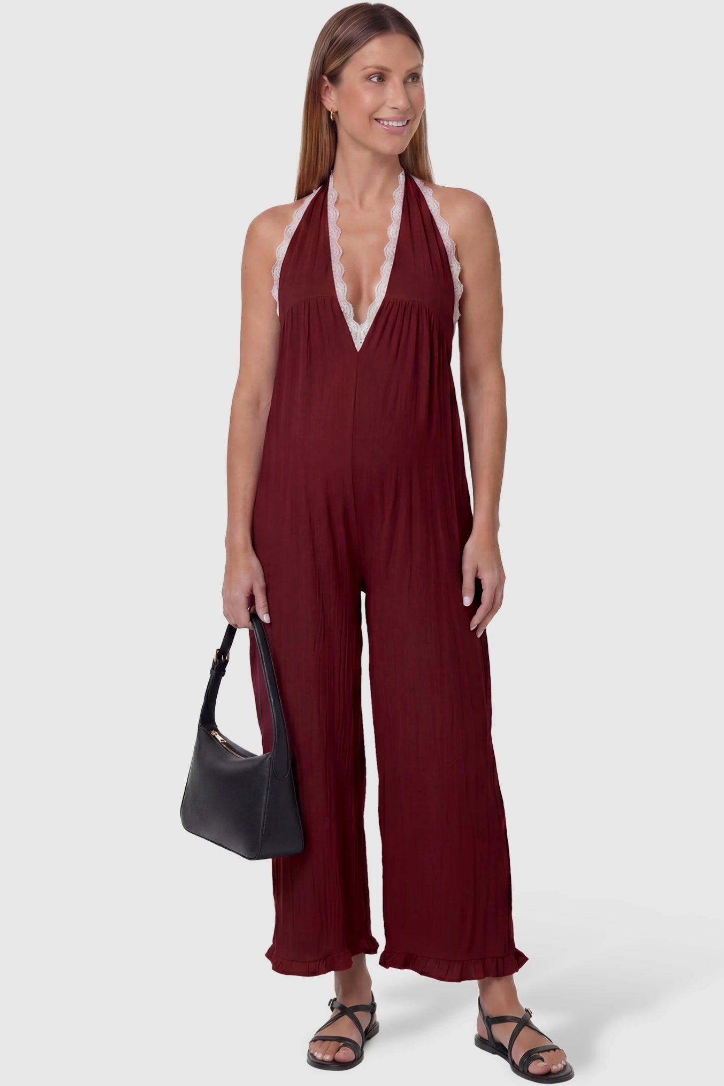 Deep V-Neck Lace Trim Wide Leg Maternity Jumpsuit Deep V-Neck Lace Trim Wide Leg Maternity Jumpsuit in Burgundy featuring a deep V-neckline with delicate lace trim on a pregnant model, front view.