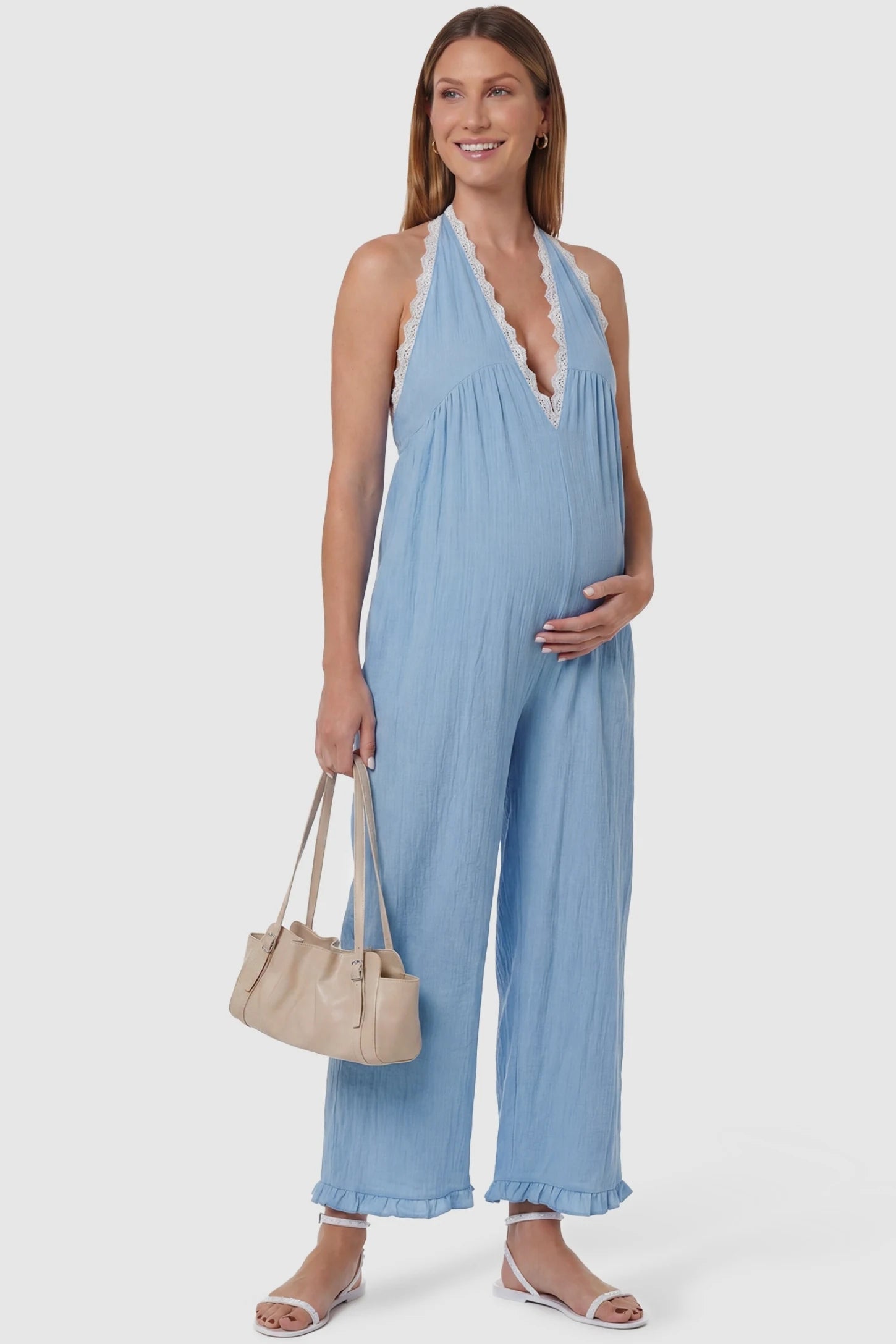 Deep V-Neck Lace Trim Wide Leg Maternity Jumpsuit Deep V-Neck Lace Trim Wide Leg Maternity Jumpsuit in Light Blue featuring delicate white lace trim neckline on a pregnant model, front view.