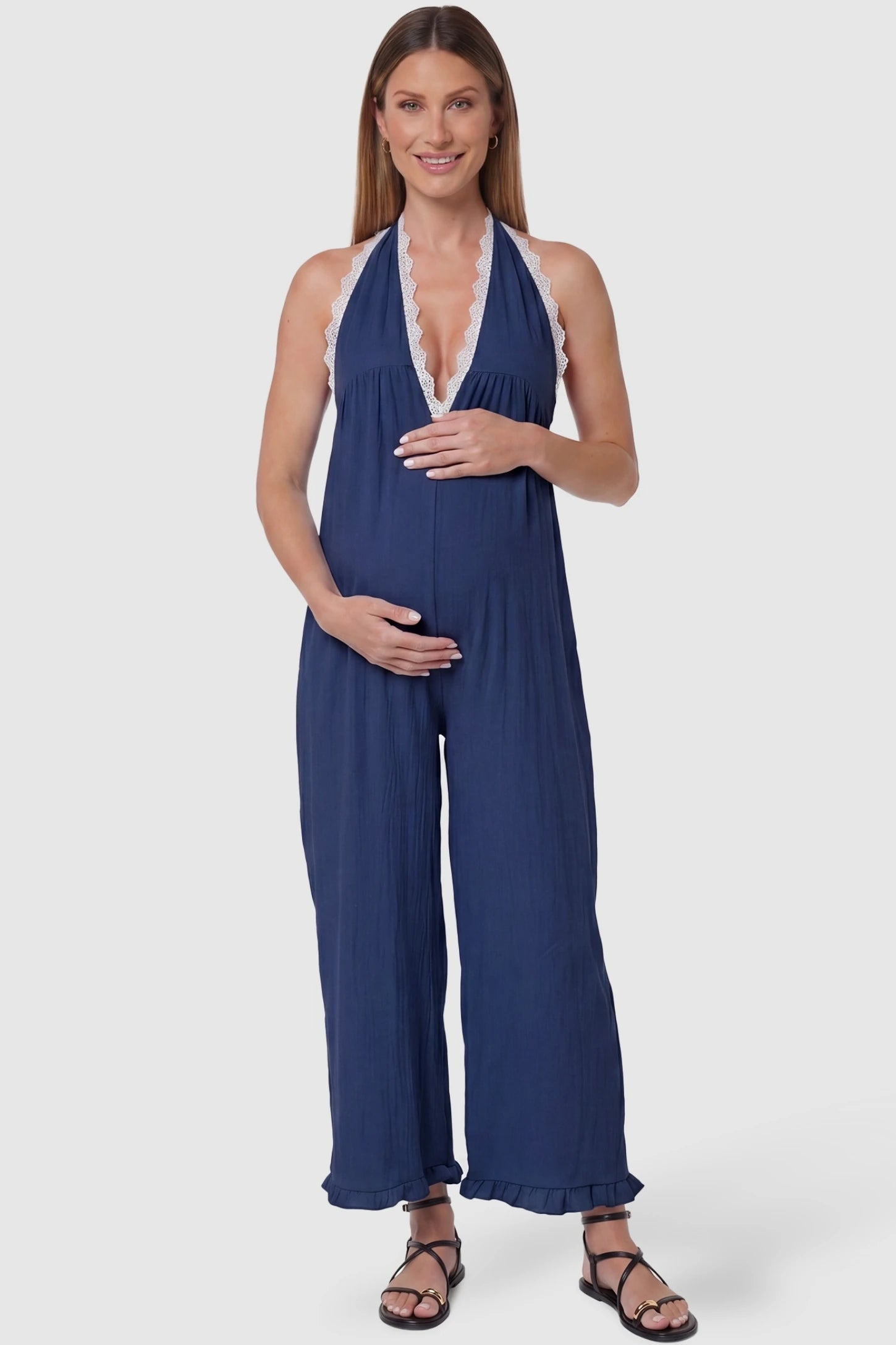 Deep V-Neck Lace Trim Wide Leg Maternity Jumpsuit Deep V-Neck Lace Trim Wide Leg Maternity Jumpsuit in Navy Blue featuring a deep V-neckline with delicate lace trim on a pregnant model, front view.