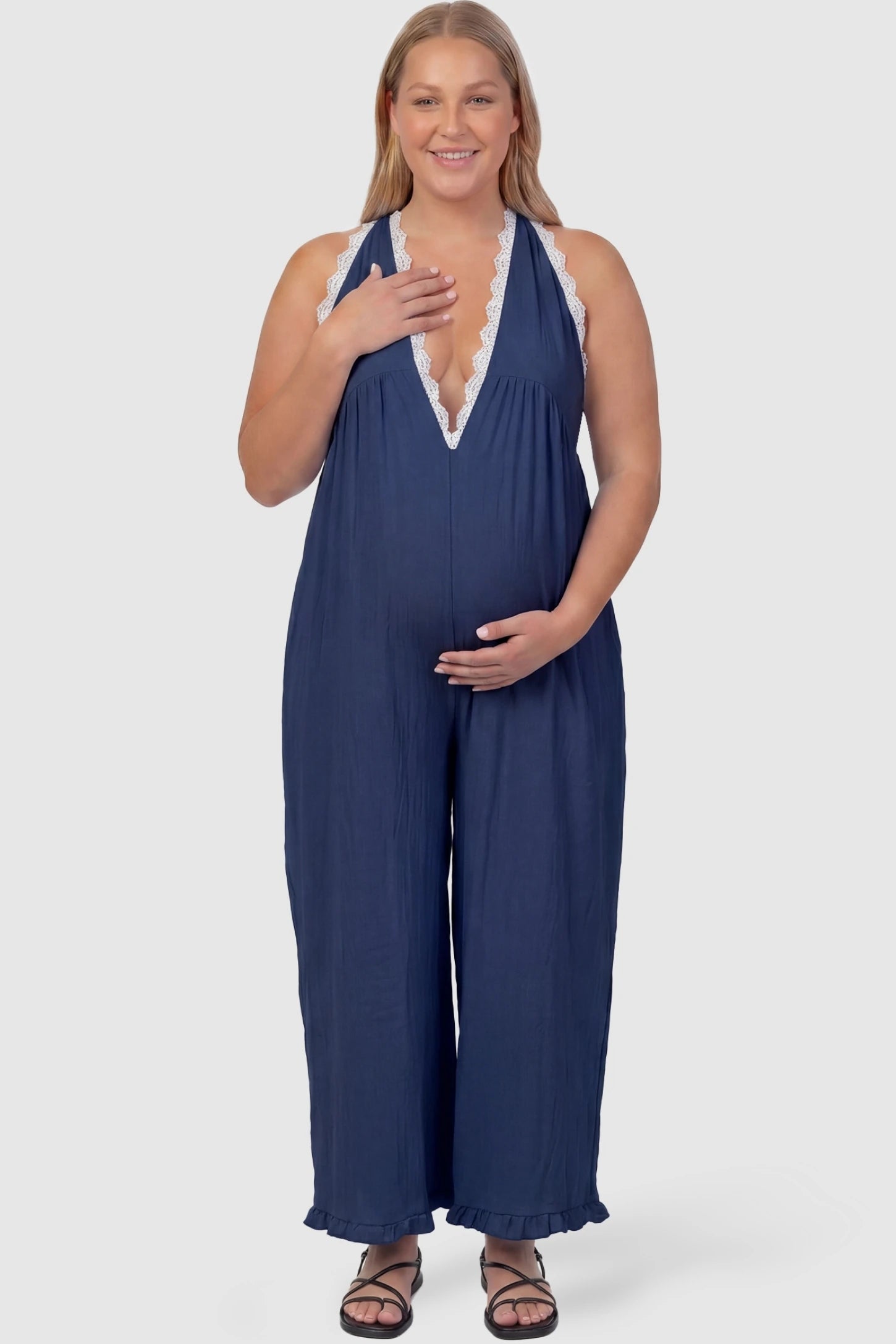 Deep V-Neck Lace Trim Wide Leg Maternity Jumpsuit Deep V-Neck Lace Trim Wide Leg Maternity Jumpsuit in Navy Blue featuring a flattering wide leg cut with lace trim neckline on a plus-size model, front view.