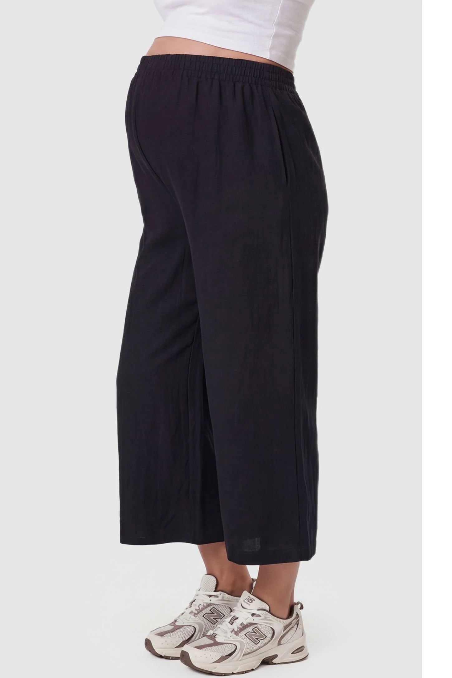 Elastic High Waisted Cropped Maternity Pants Elastic High Waisted Cropped Maternity Pants in Black featuring a flexible waistband on a pregnant model, side