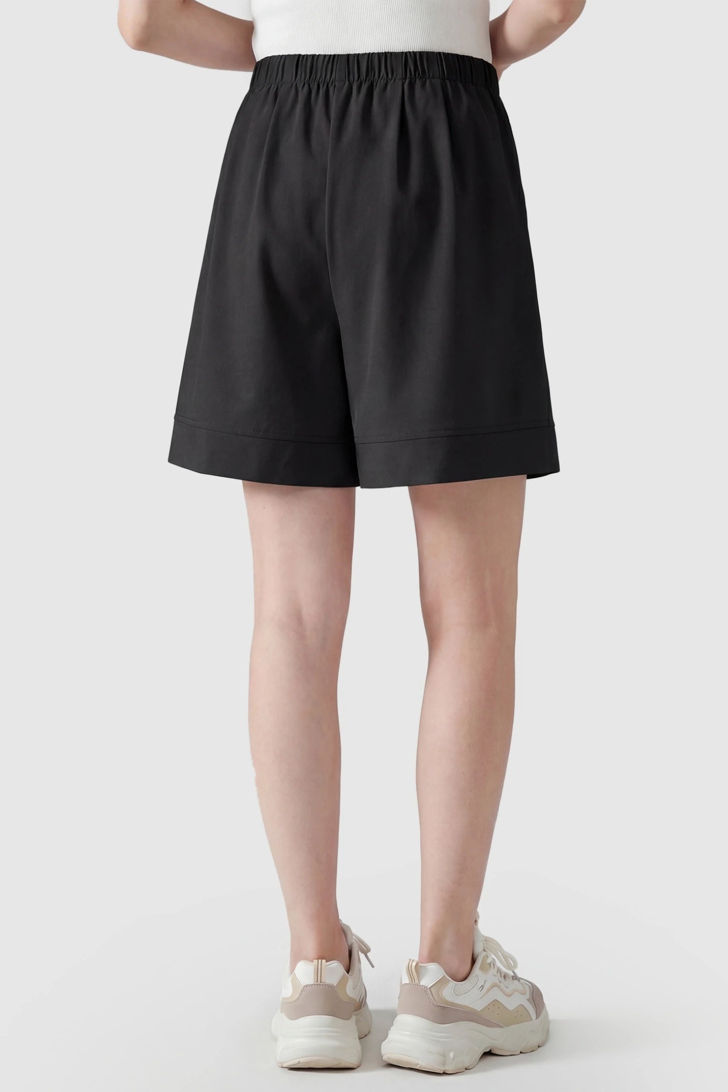 Pocketed Side Drawstring Maternity Shorts Back view of Black Wide Leg Maternity Lounge Shorts featuring a flattering draped silhouette on a postpartum model.