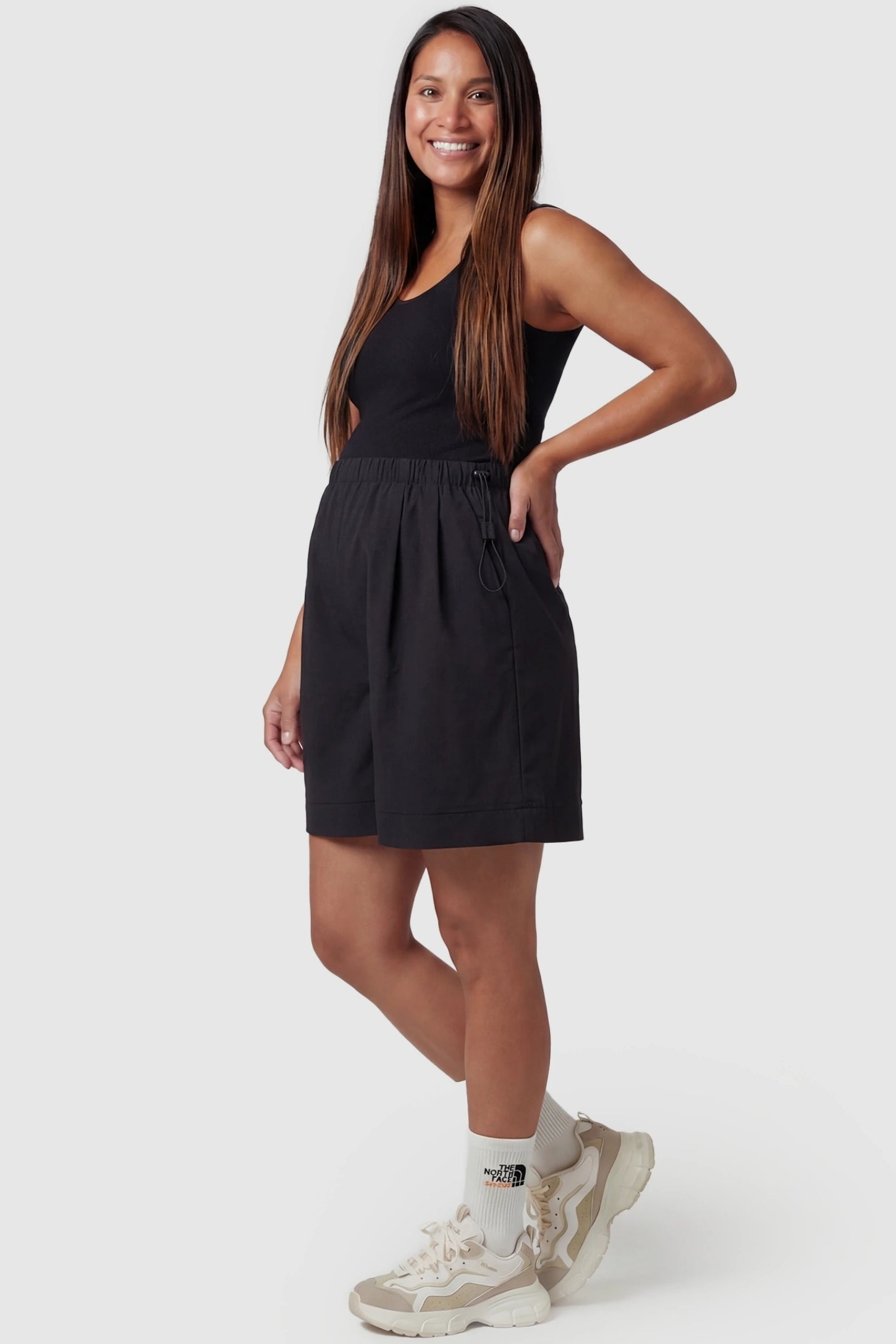 Pocketed Side Drawstring Maternity Shorts Black Elasticated Waist Soft Wide Leg Maternity Shorts featuring a supportive gathered waistband on a pregnant model, front view.