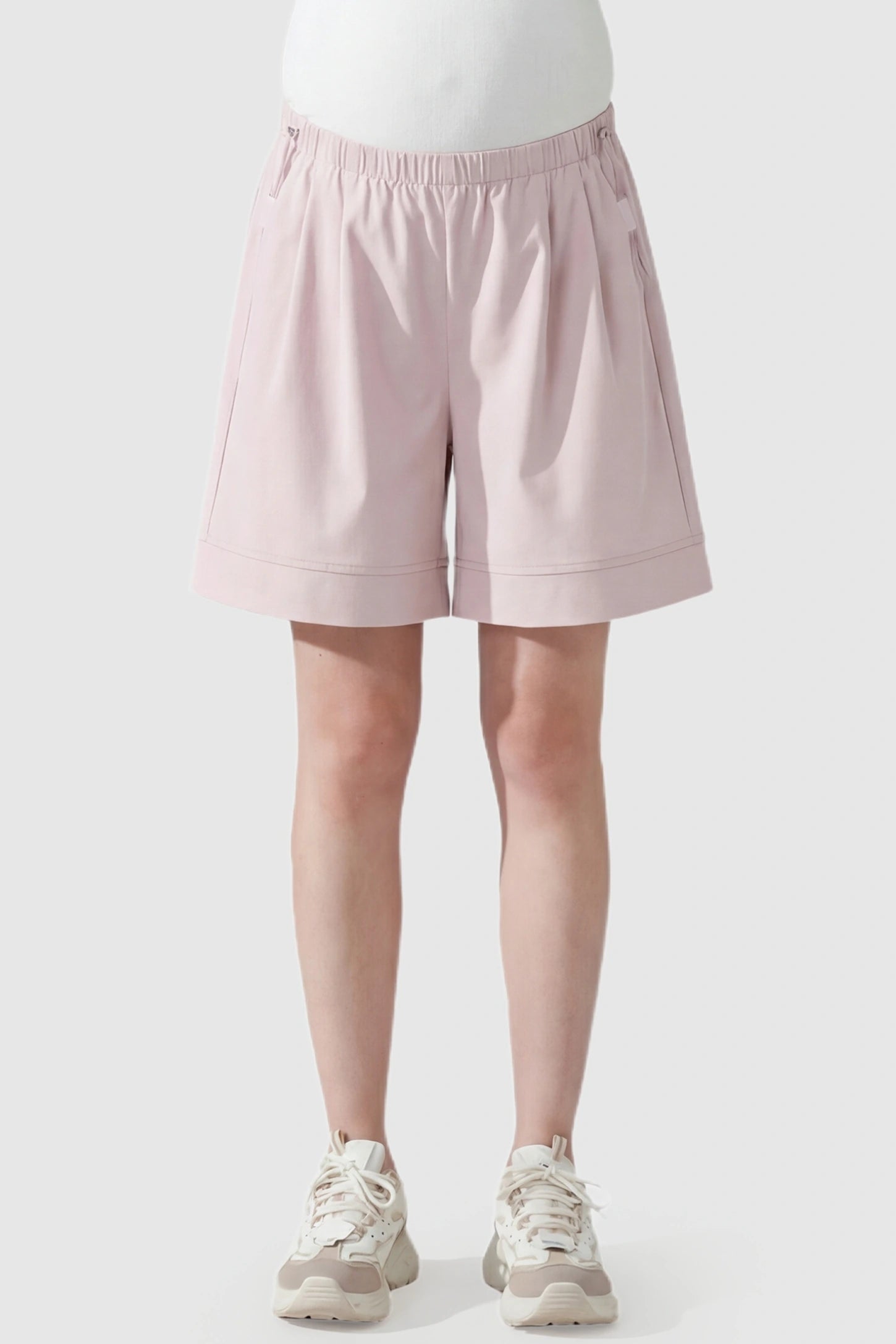 Pocketed Side Drawstring Maternity Shorts Front view of Light Pink Elasticated Waist Maternity Shorts featuring soft-touch fabric on a pregnant model.