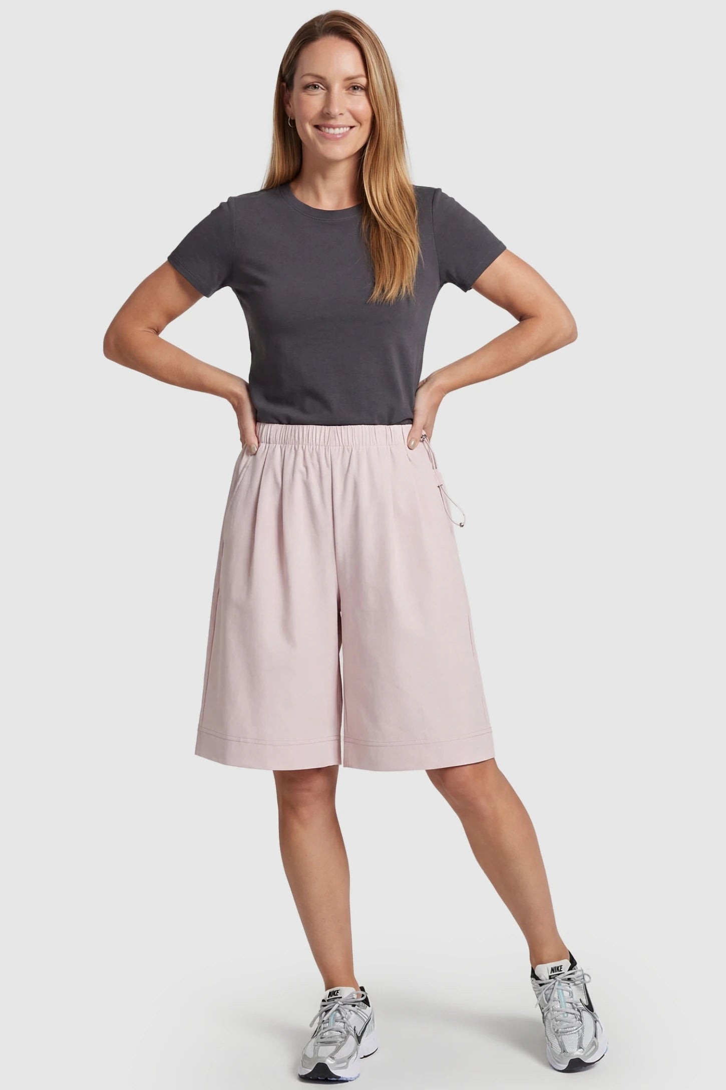 Pocketed Side Drawstring Maternity Shorts Light Pink Elasticated Waist Lounge Shorts featuring deep side pockets on a postpartum model, front view.