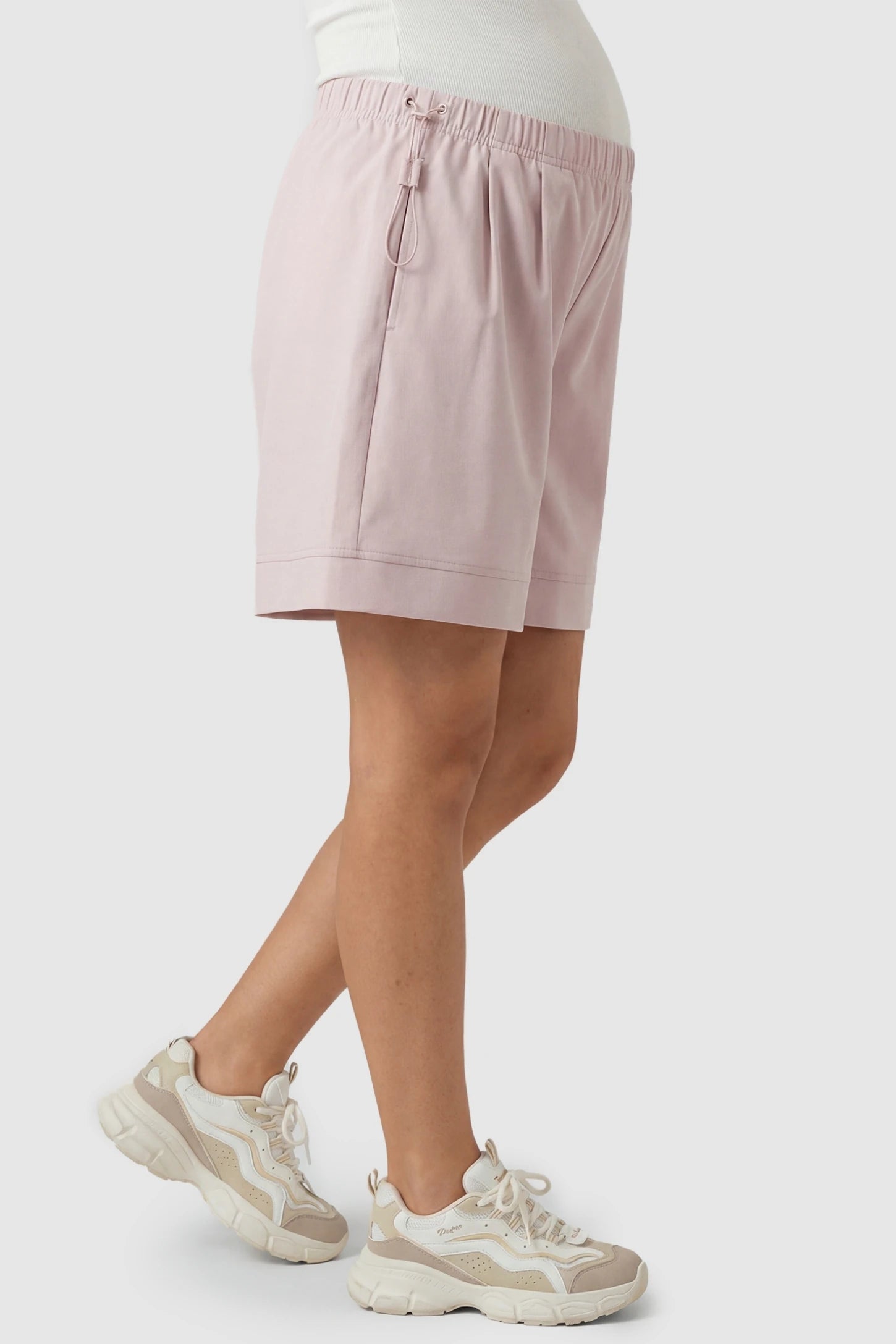 Pocketed Side Drawstring Maternity Shorts Light Pink Soft Wide Leg Maternity Lounge Shorts featuring a high-rise stretchy waistband on a pregnant model, side view.