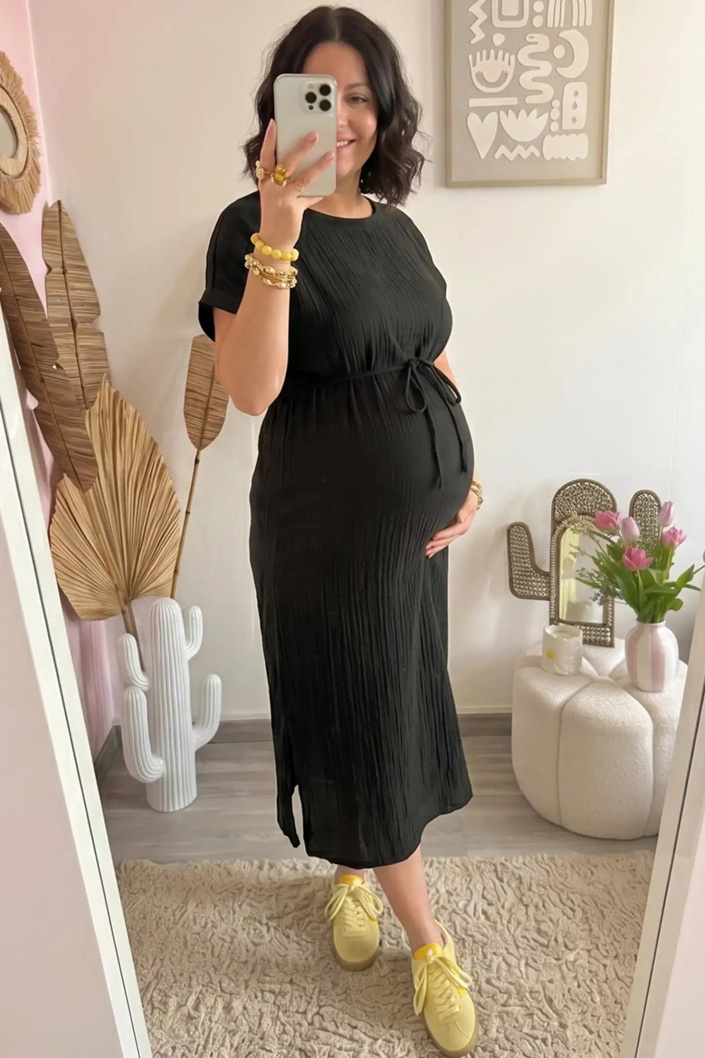 Empire Waist Round Neck Maternity Midi Dress Empire Waist Round Neck Maternity Midi Dress in Black featuring elasticated waistband with a decorative tie detail on a plus size pregnant woman in indoor setting, front view.