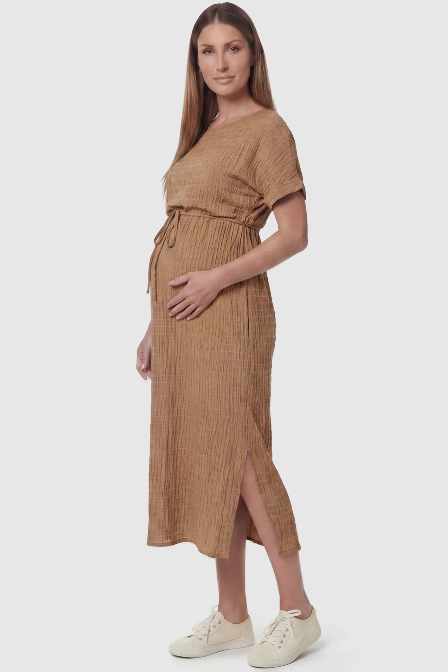 Empire Waist Round Neck Maternity Midi Dress Empire Waist Round Neck Maternity Midi Dress in Pink featuring elasticated waistband with a decorative tie detail on a pregnant model, side view.