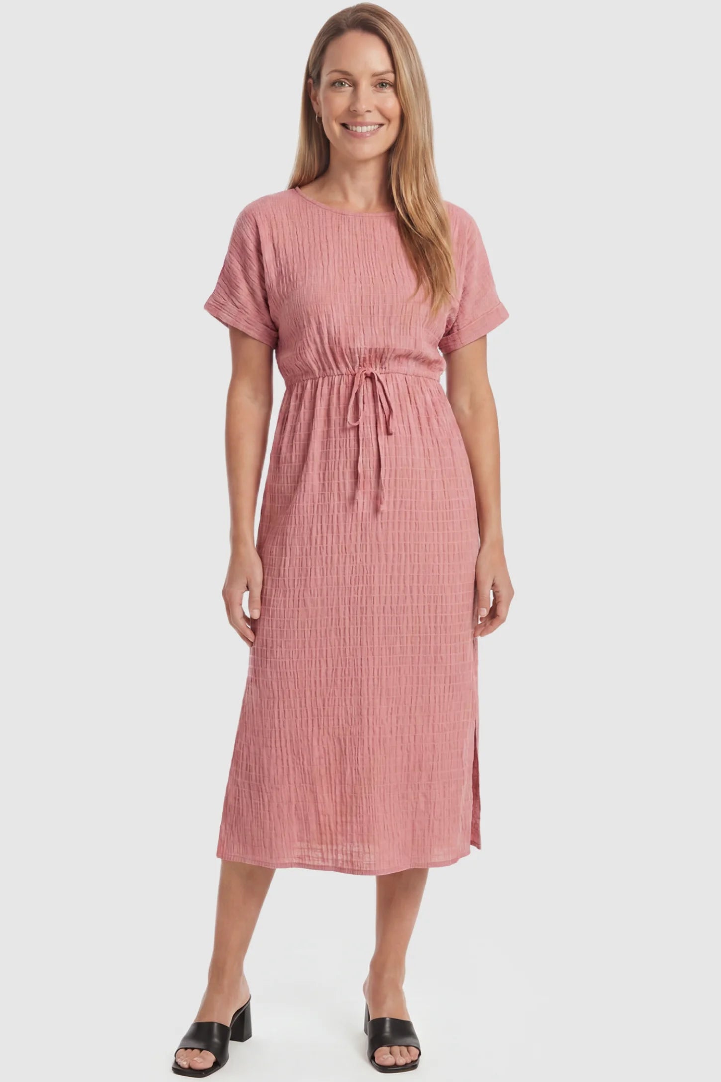Empire Waist Round Neck Maternity Midi Dress Empire Waist Round Neck Maternity Midi Dress in Pink featuring elasticated waistband with a decorative tie detail on a postpartum model, front view.