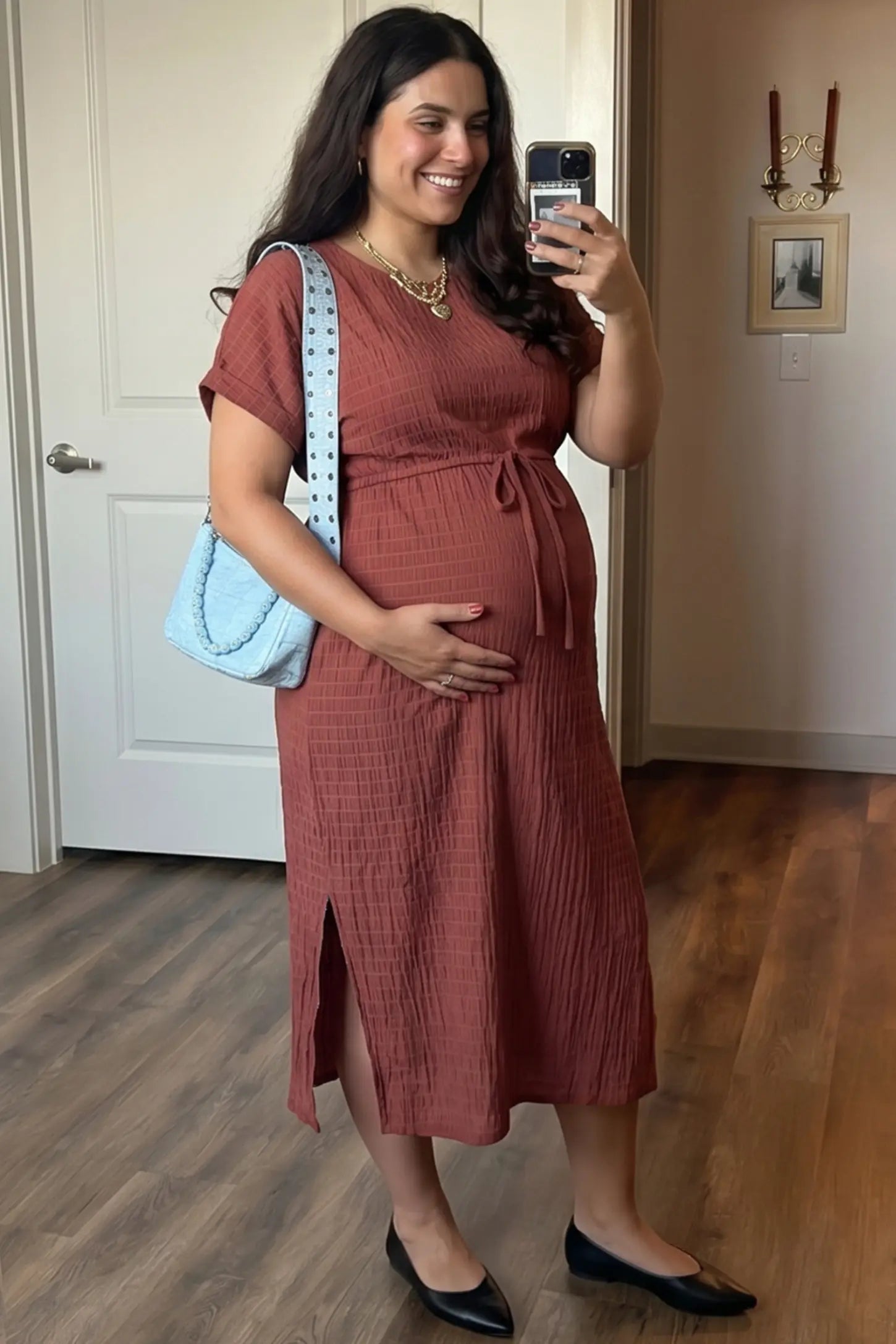 Empire Waist Round Neck Maternity Midi Dress Empire Waist Round Neck Maternity Midi Dress in Wine Red featuring elasticated waistband with a decorative tie detail on a plus size pregnant woman in indoor setting, front view.