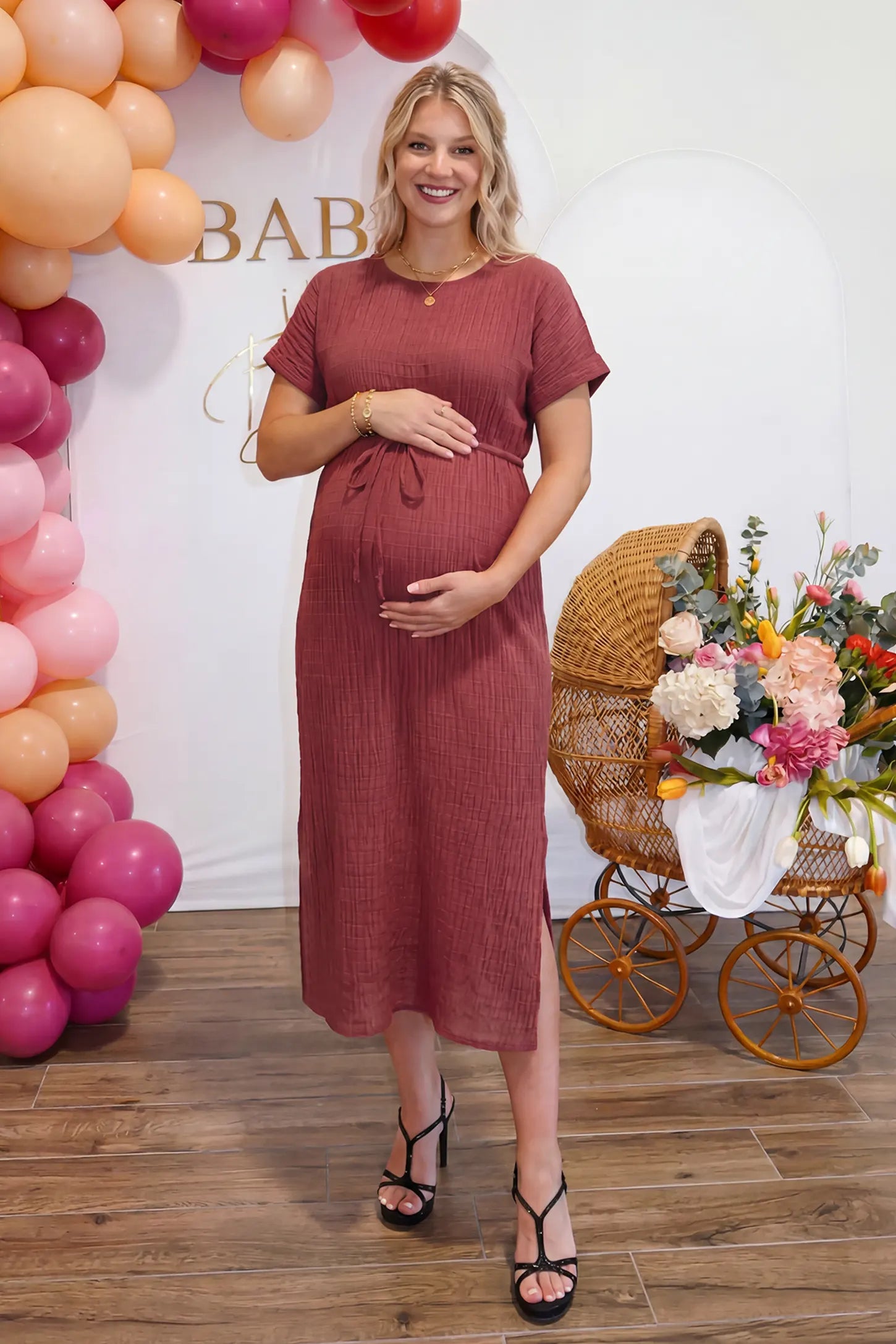 Empire Waist Round Neck Maternity Midi Dress in Wine Red featuring elasticated waistband with a decorative tie detail on a plus size pregnant woman, front view.