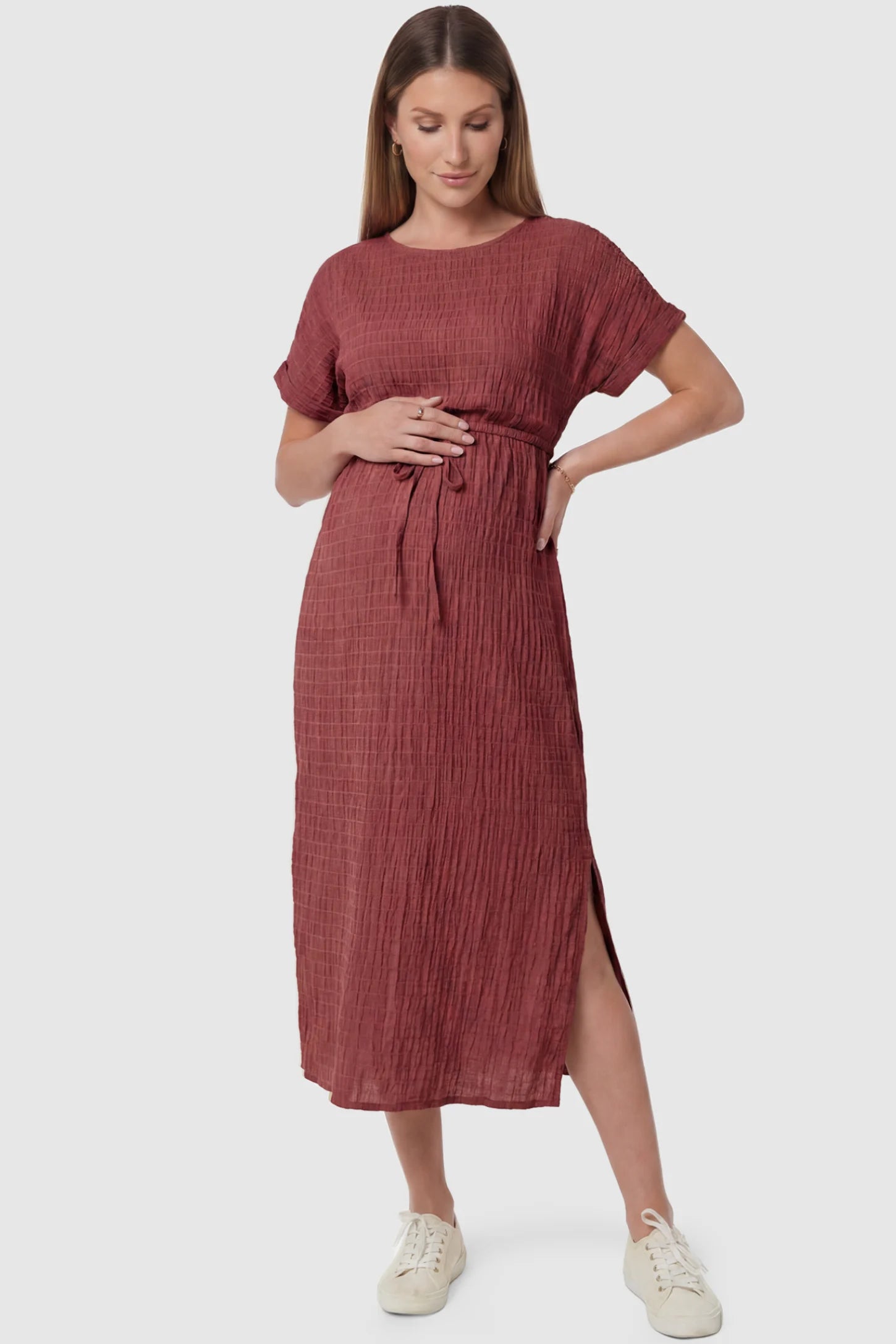 Empire Waist Round Neck Maternity Midi Dress Empire Waist Round Neck Maternity Midi Dress in Wine Red featuring elasticated waistband with a decorative tie detail on a pregnant model, front view.