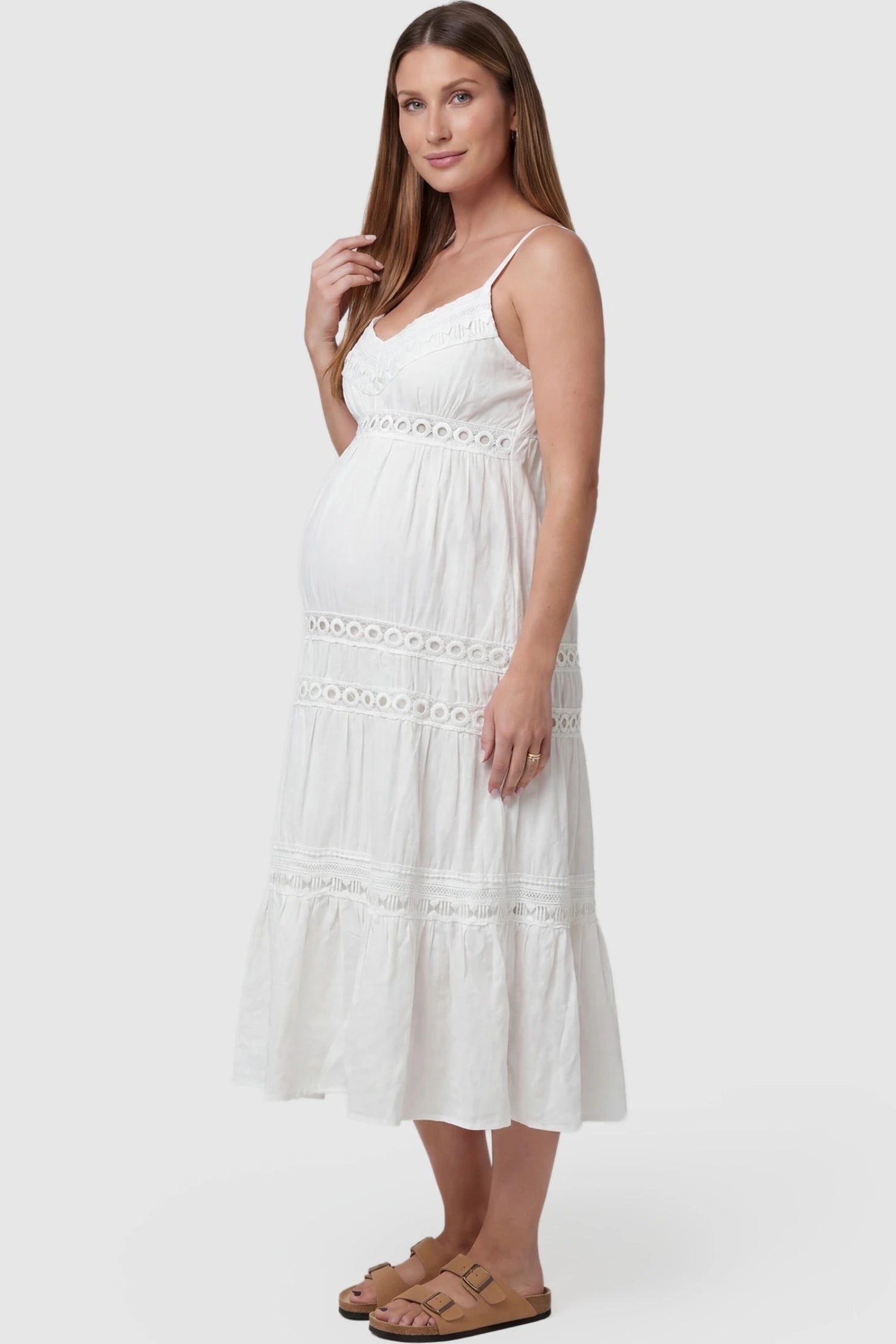 Eyelet Lace Cami Midi Maternity Dress Eyelet Lace Cami Midi Maternity Dress in White featuring circle eyelet lace trim on a pregnant model, side view.