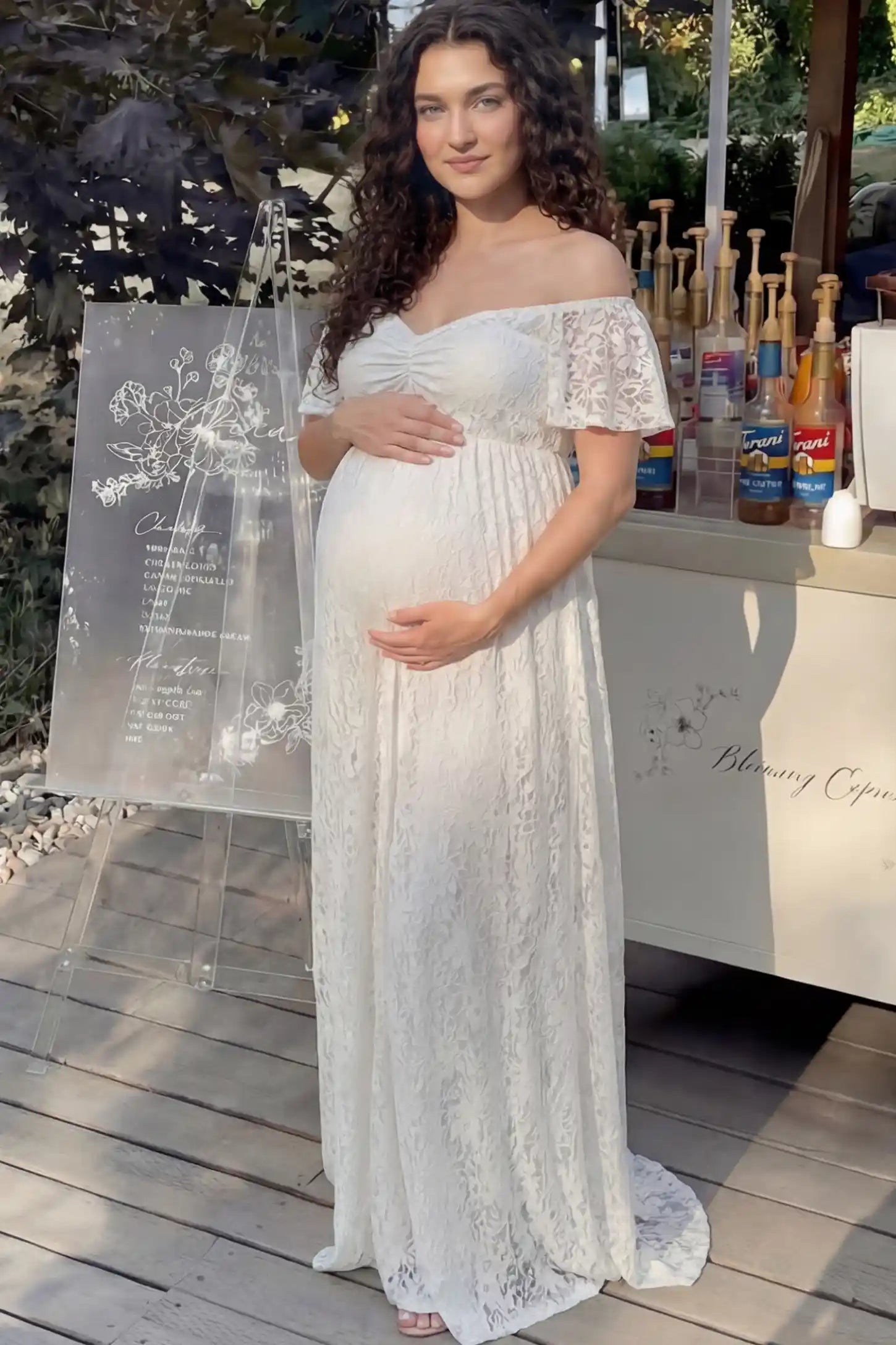 Lace Off Shoulder Maternity Maxi Dress Lace Off Shoulder Maternity Maxi Dress in white featuring off the shoulder neckline on a pregnant woman showing front.