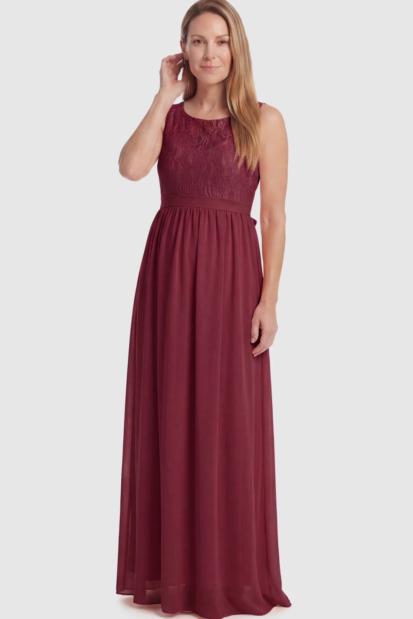 Floral Lace Sleeveless Maternity Maxi Dress Floral Lace Sleeveless Maternity Maxi Dress in Burgundy featuring a flowing skirt on a postpartum model.