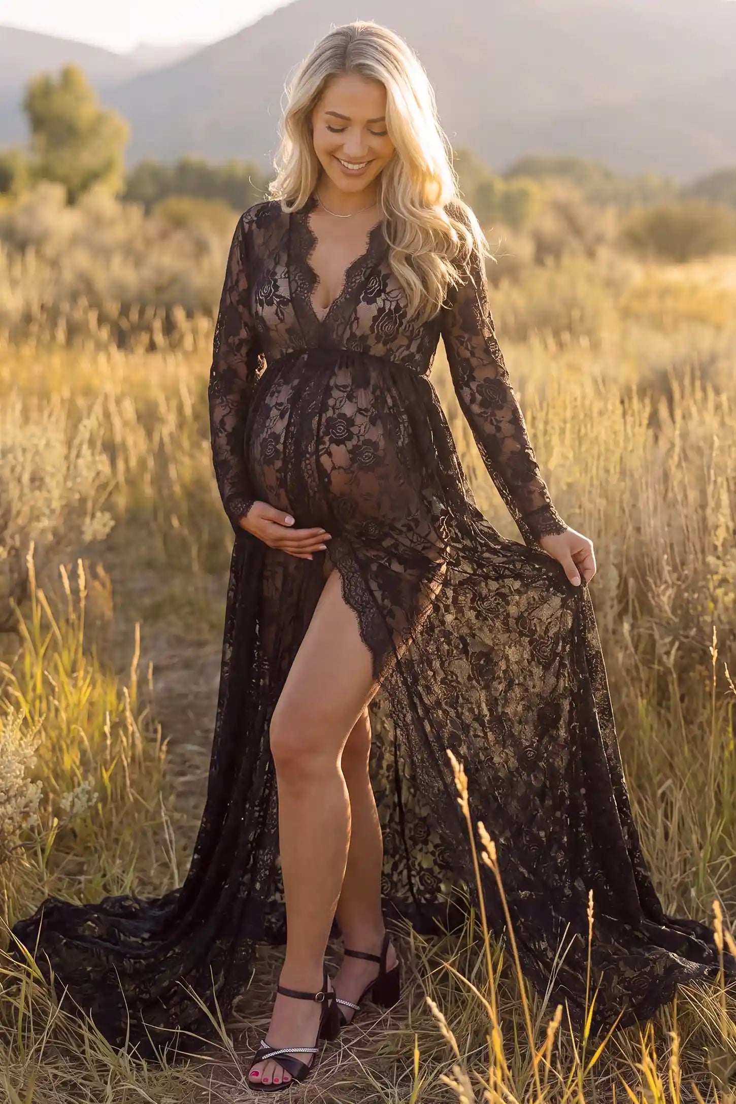 Floral Lace V-Neck Long Sleeve Maternity Photoshoot Gown in Black featuring long sleeves and high front slit on a pregnant woman during home photoshoot.