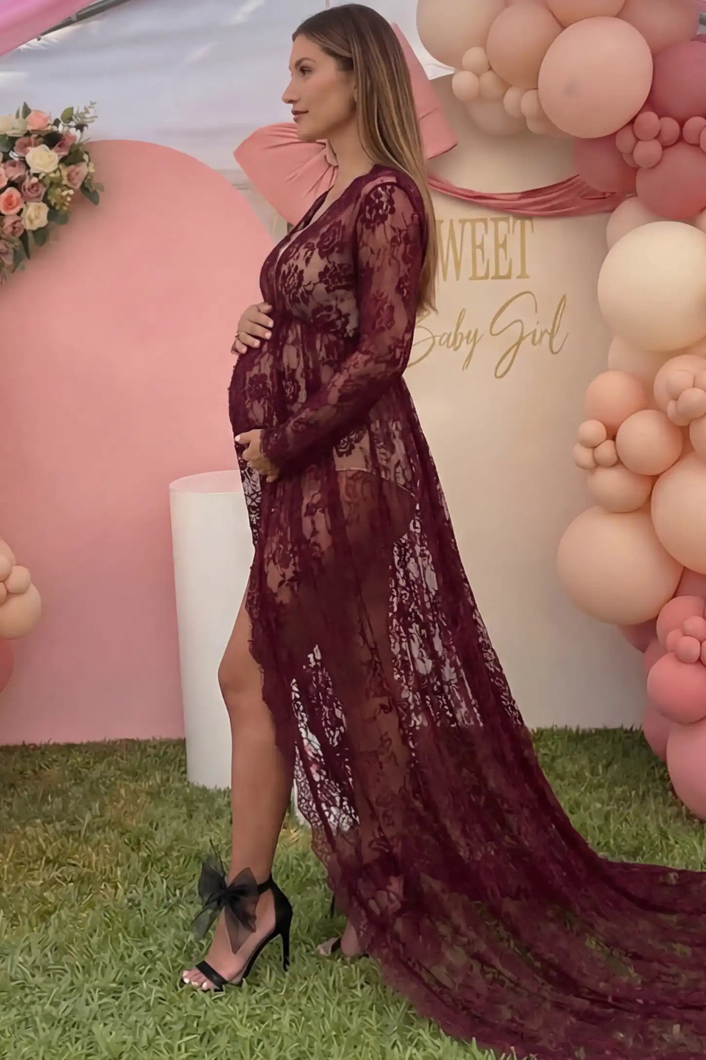 Floral Lace V-Neck Long Sleeve Maternity Photoshoot Gown Floral Lace V-Neck Long Sleeve Maternity Photoshoot Gown in Burgundy featuring long sleeves and high front slit on a pregnant model showing side.