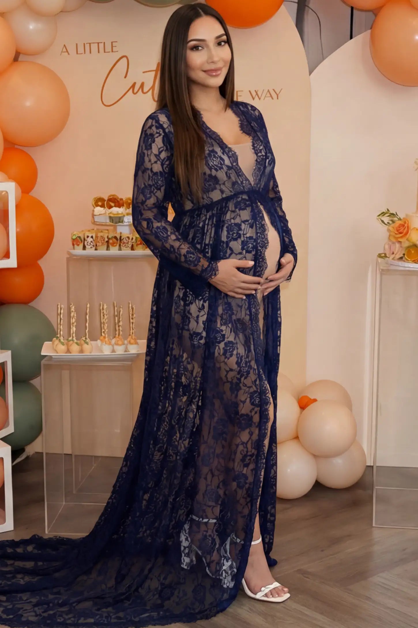 Floral Lace V-Neck Long Sleeve Maternity Photoshoot Gown Floral Lace V-Neck Long Sleeve Maternity Photoshoot Gown in Navy Blue featuring long sleeves and high front slit on a pregnant woman during home photoshoot.
