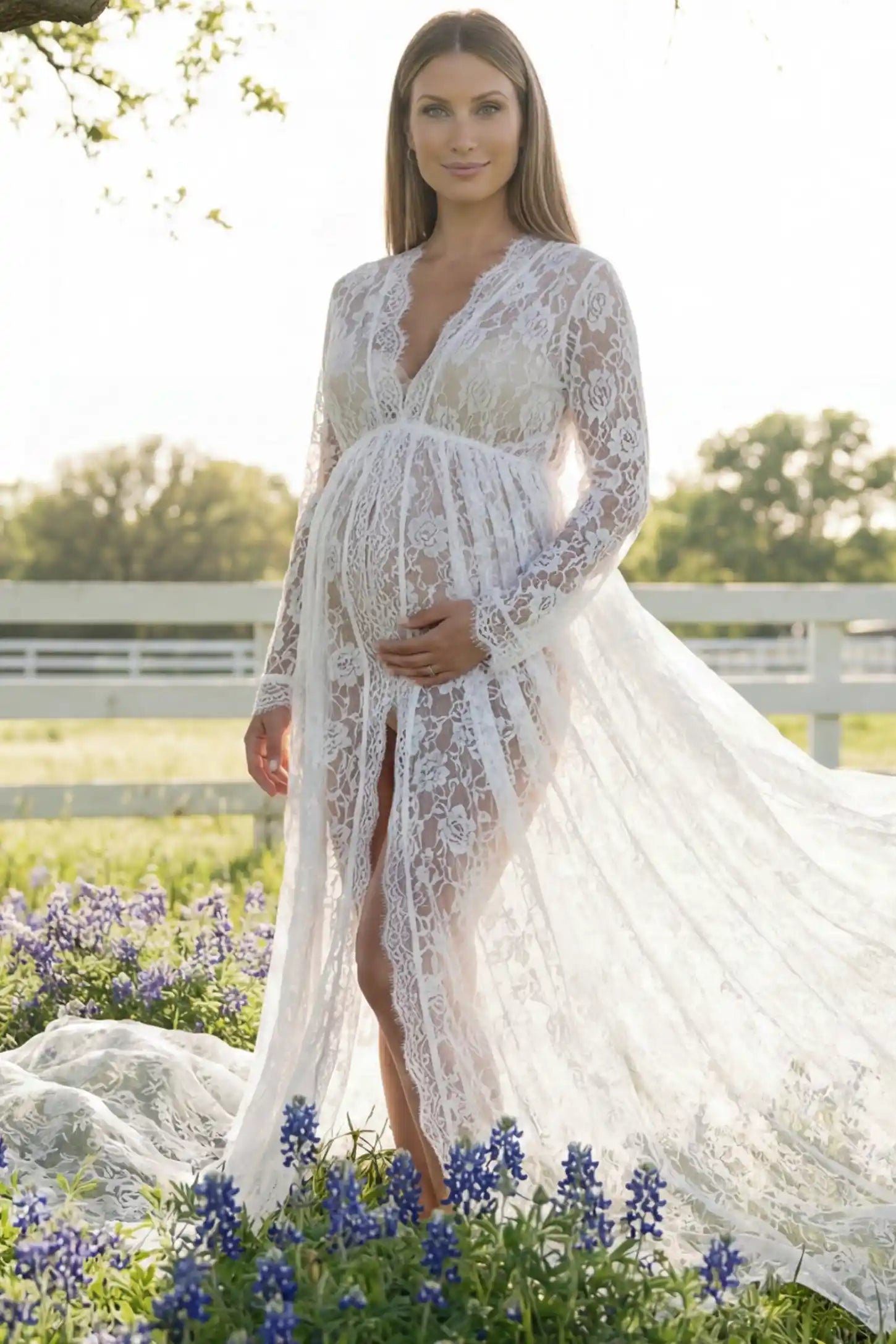 Floral Lace V-Neck Long Sleeve Maternity Photoshoot Gown Floral Lace V-Neck Long Sleeve Maternity Photoshoot Gown in White featuring long sleeves and high front slit on a pregnant model posing front.