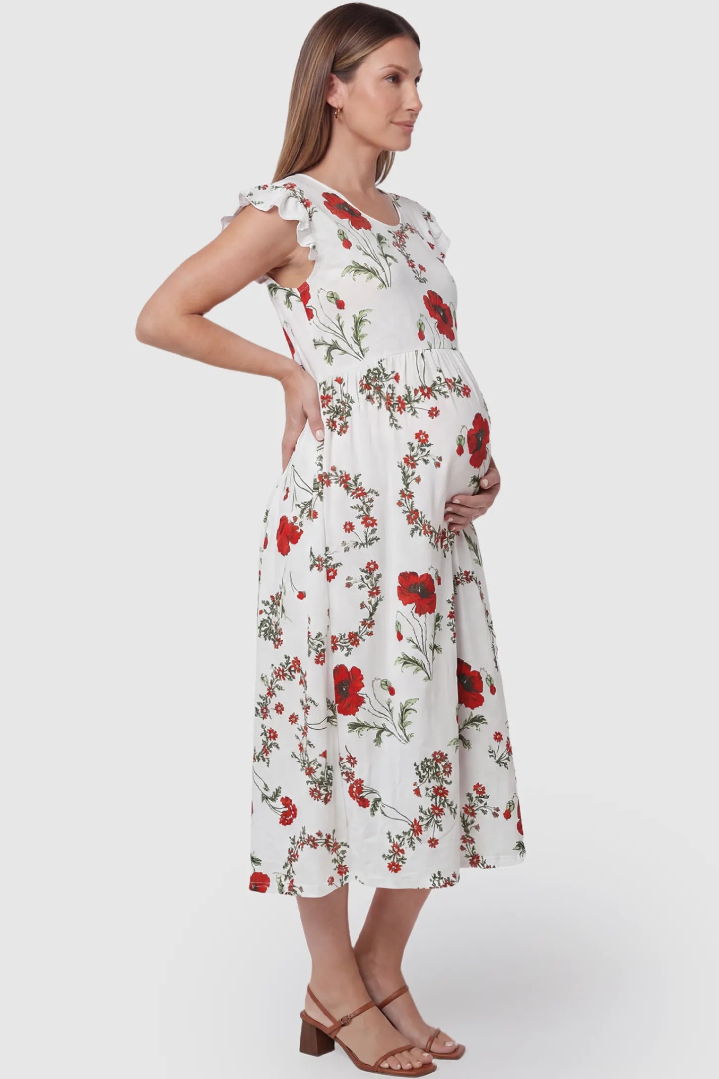 Floral Print Scoop Neck Maternity Maxi Dress Floral Print Scoop Neck Maxi Maternity Dress in White with Red Poppy Prints featuring ruffle sleeves on a pregnant model side view.