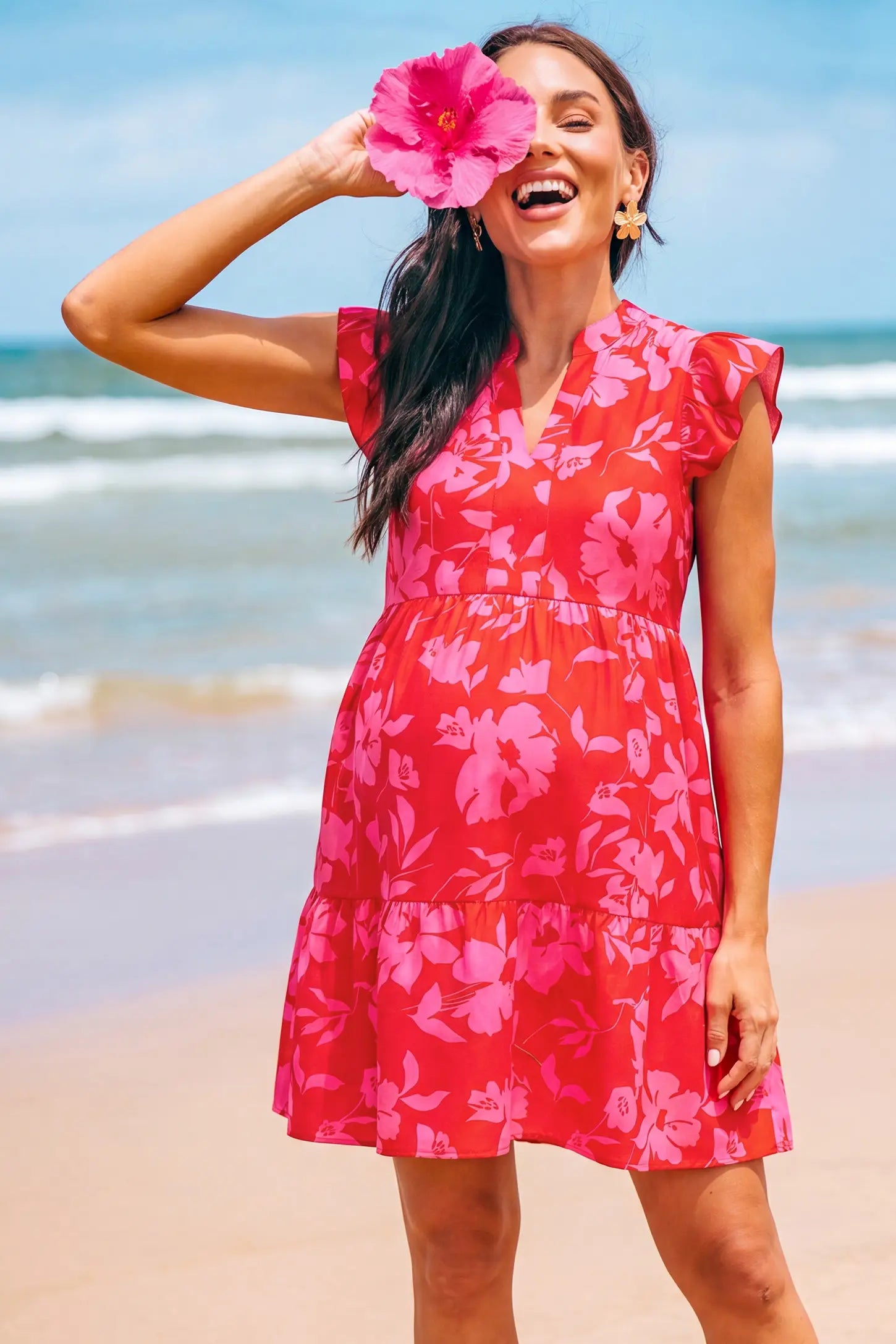 Floral Print V-Neck Flutter Sleeve Maternity Short Dress Floral Print V-Neck Flutter Sleeve Maternity Short Dress in Poppy Red with floral print and flutter sleeves, lifestyle view on a pregnant model.