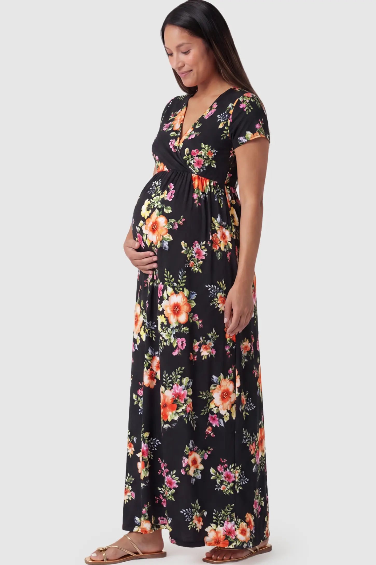 Floral Print V-Neck Maternity Maxi Dress Floral Print V-Neck Maternity Maxi Dress in Black featuring a vibrant floral pattern on a pregnant model showing side.