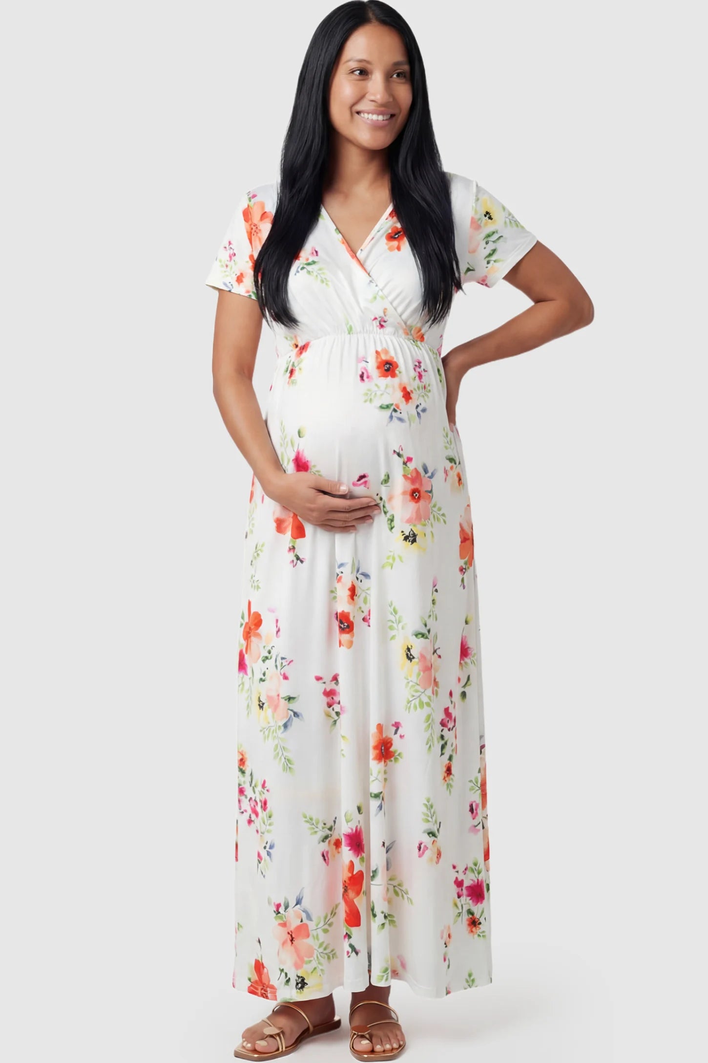 Floral Print V-Neck Maternity Maxi Dress in White featuring a vibrant floral pattern on a pregnant model showing front.