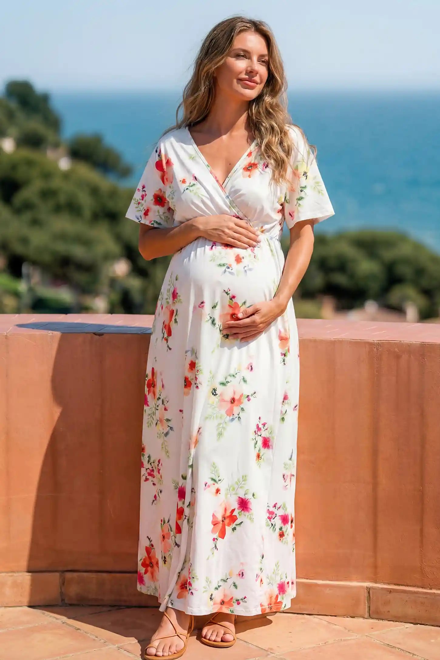 Floral Print V-Neck Maternity Maxi Dress in White featuring a vibrant floral pattern on a pregnant woman showing front.
