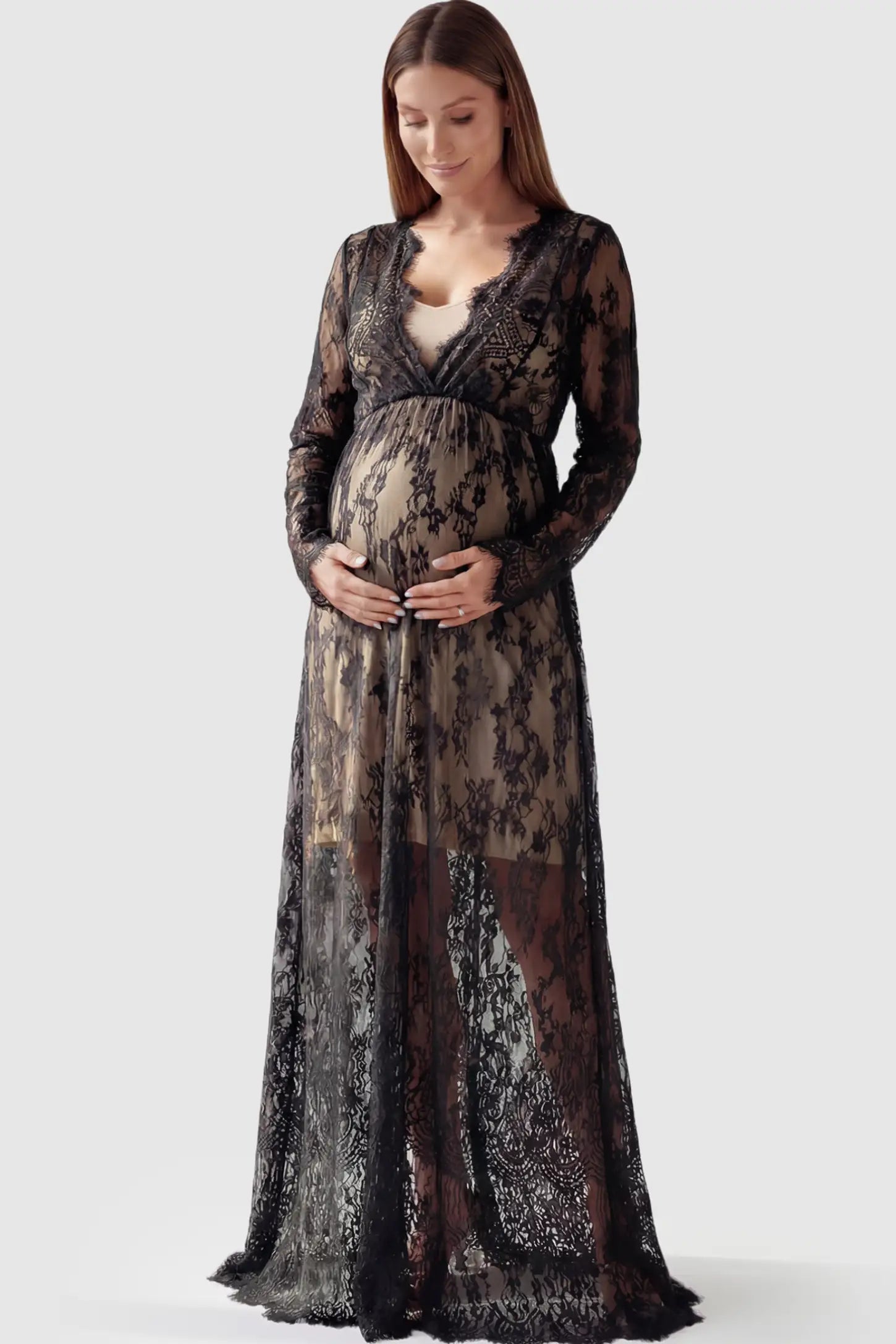 Floral Sheer Lace Maternity Gown in Black featuring scalloped v-neck and long sleeves on a pregnant model showing front.
