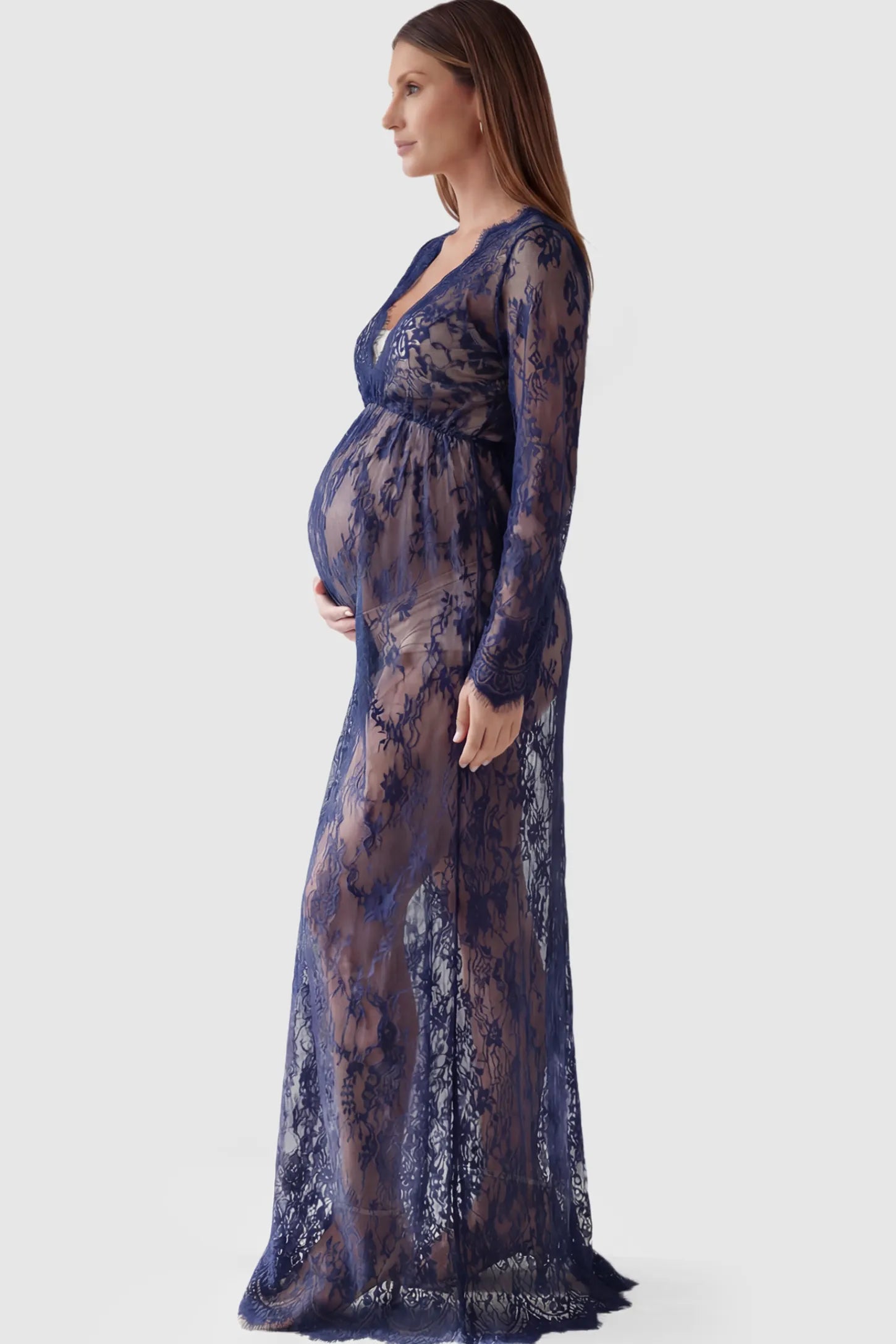 Floral Sheer Lace Long Sleeve Maternity Photoshoot Gown Floral Sheer Lace Maternity Gown in Dark Blue featuring scalloped v-neck and long sleeves on a pregnant model showing side.