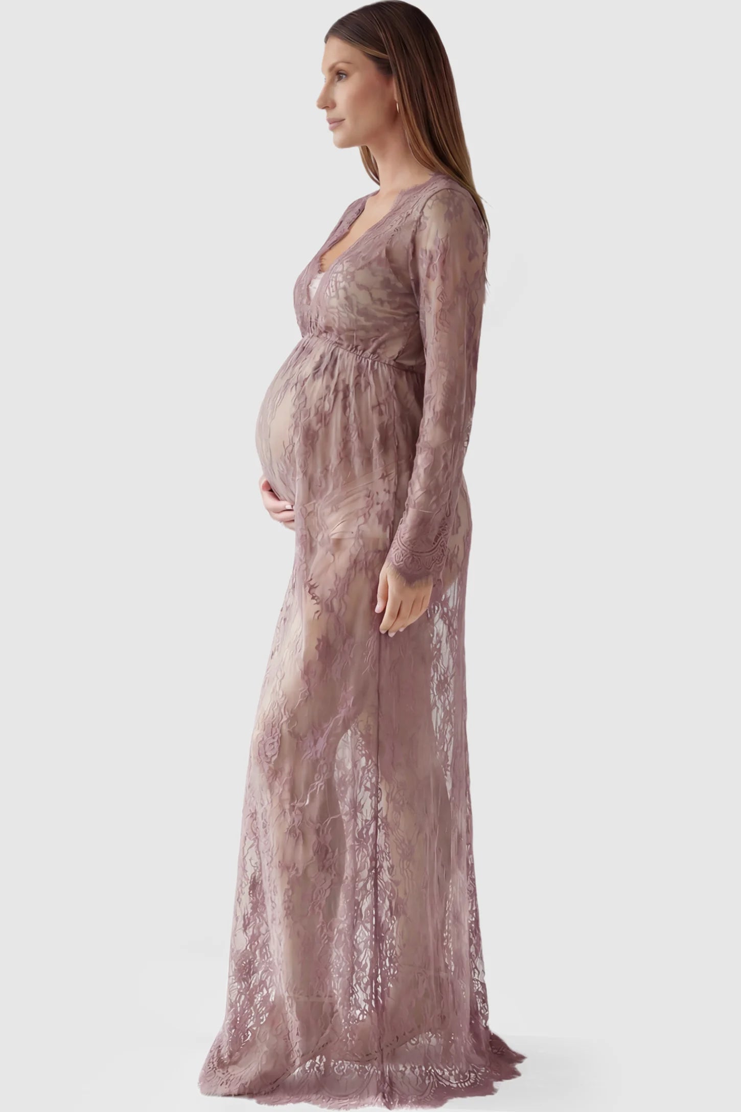 Floral Sheer Lace Long Sleeve Maternity Photoshoot Gown Floral Sheer Lace Maternity Gown in Dusty Mauve featuring scalloped v-neck and long sleeves on a pregnant model showing side.