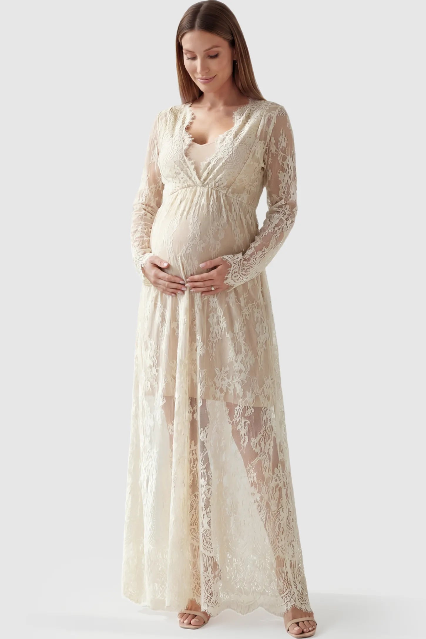 Floral Sheer Lace Long Sleeve Maternity Photoshoot Gown Floral Sheer Lace Maternity Gown in Ivory featuring scalloped v-neck and long sleeves on a pregnant model showing front.