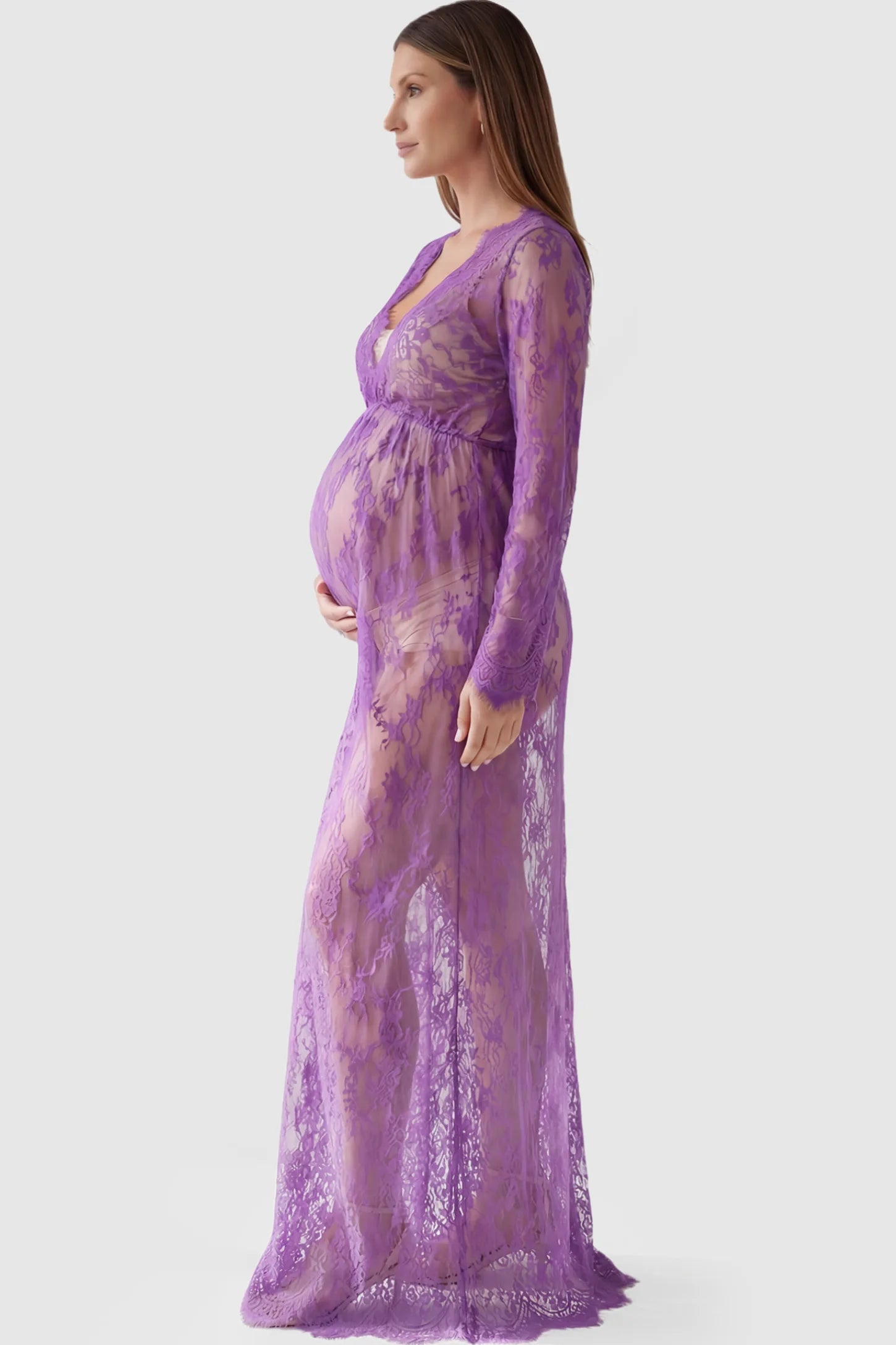 Floral Sheer Lace Long Sleeve Maternity Photoshoot Gown Floral Sheer Lace Maternity Gown in Purple featuring scalloped v-neck and long sleeves on a pregnant model showing side.