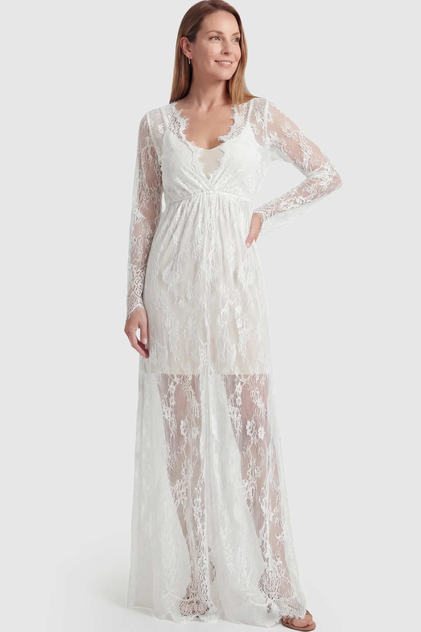 Floral Sheer Lace Long Sleeve Maternity Photoshoot Gown Floral Sheer Lace Maternity Gown in White featuring scalloped v-neck and long sleeves on a postpartum model showing front.