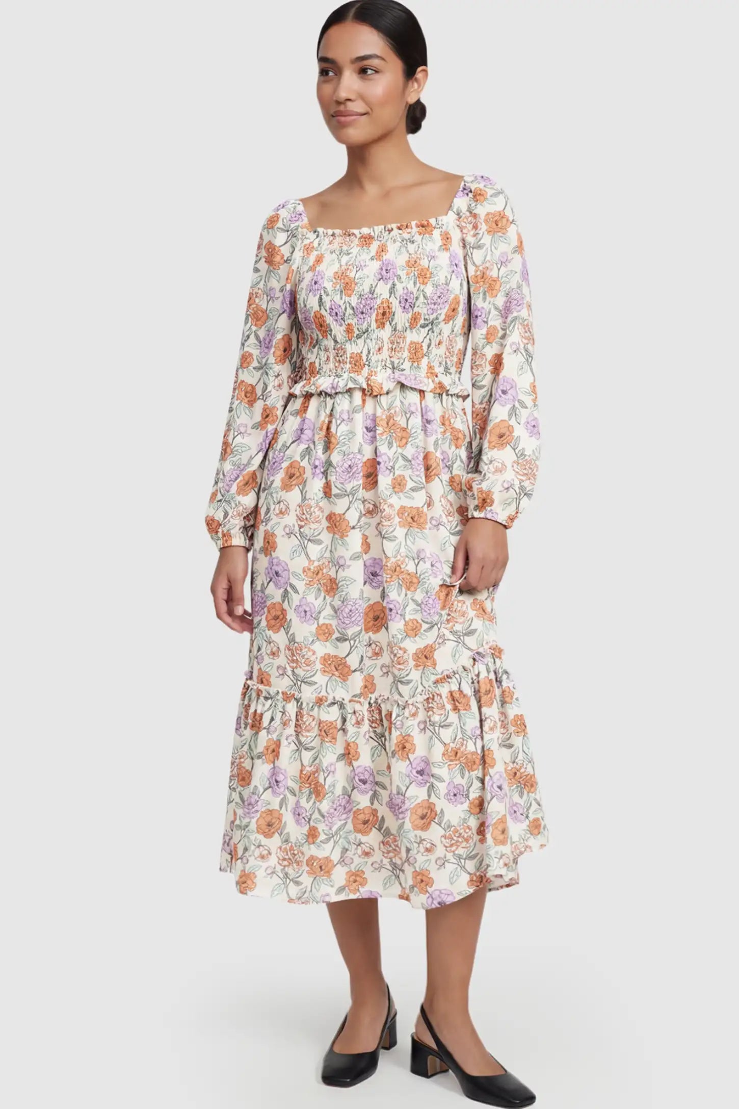 Floral Smocked Bodice Tiered Maternity Midi Dress Floral Smocked Bodice Tiered Midi Dress in floral print featuring a smocked square neckline on a postpartum model showing front.