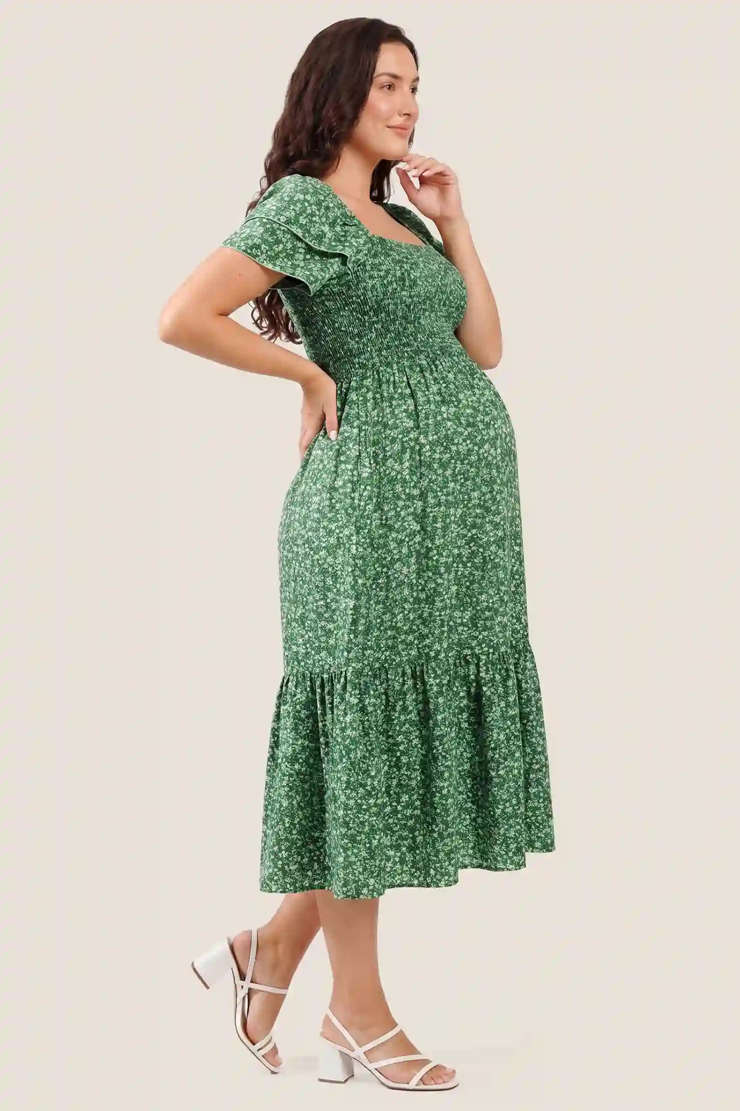 Floral Smocked Square Neck Tiered Maternity Midi Dress Floral Smocked Square Neck Tiered Maternity Midi Dress in Peacock Green showcasing the comfortable tiered silhouette, side view on a pregnant model.