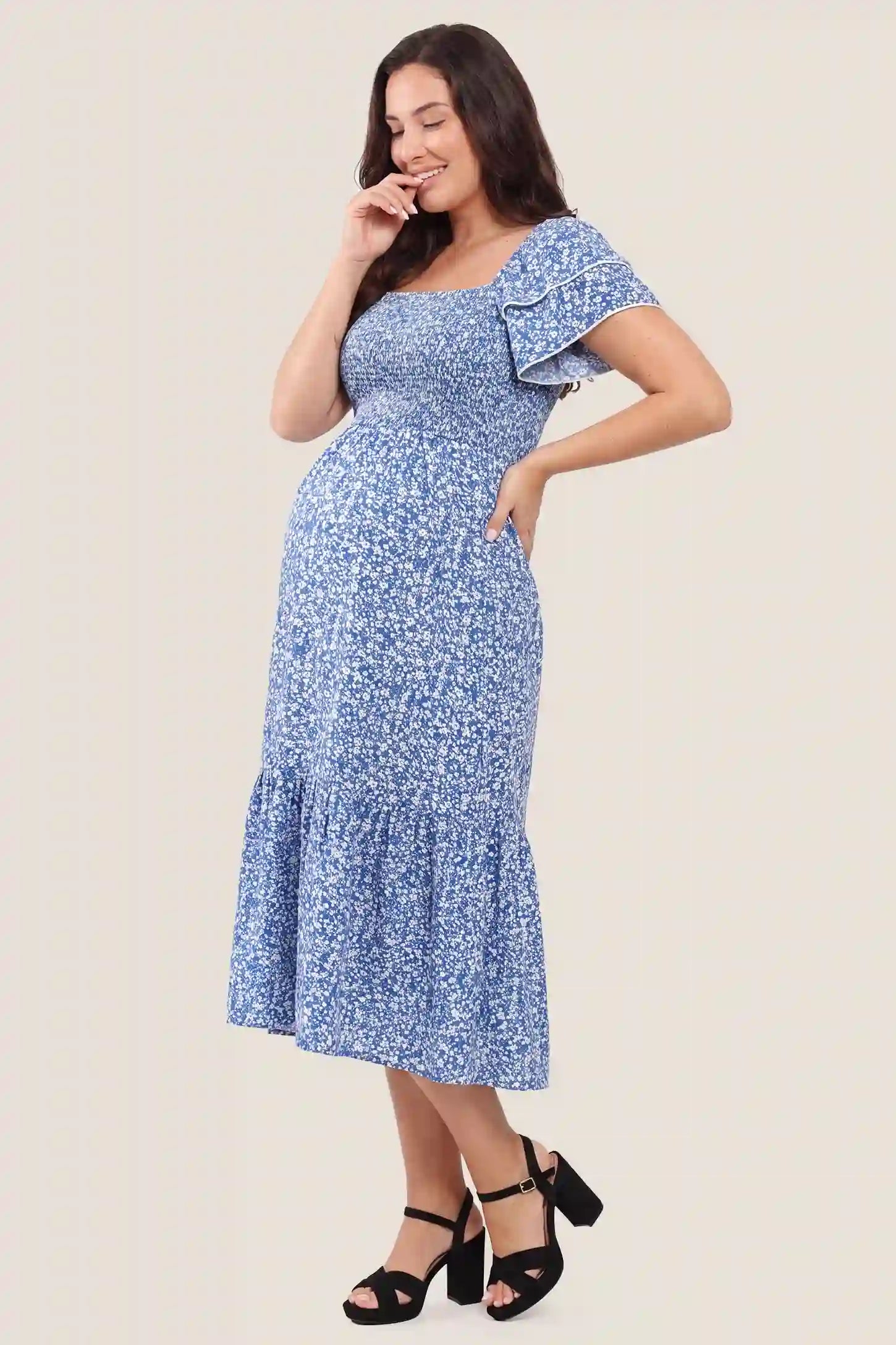 Floral Smocked Square Neck Tiered Maternity Midi Dress Floral Smocked Square Neck Tiered Maternity Midi Dress in Royal Blue showcasing the comfortable tiered silhouette, side view on a pregnant model.