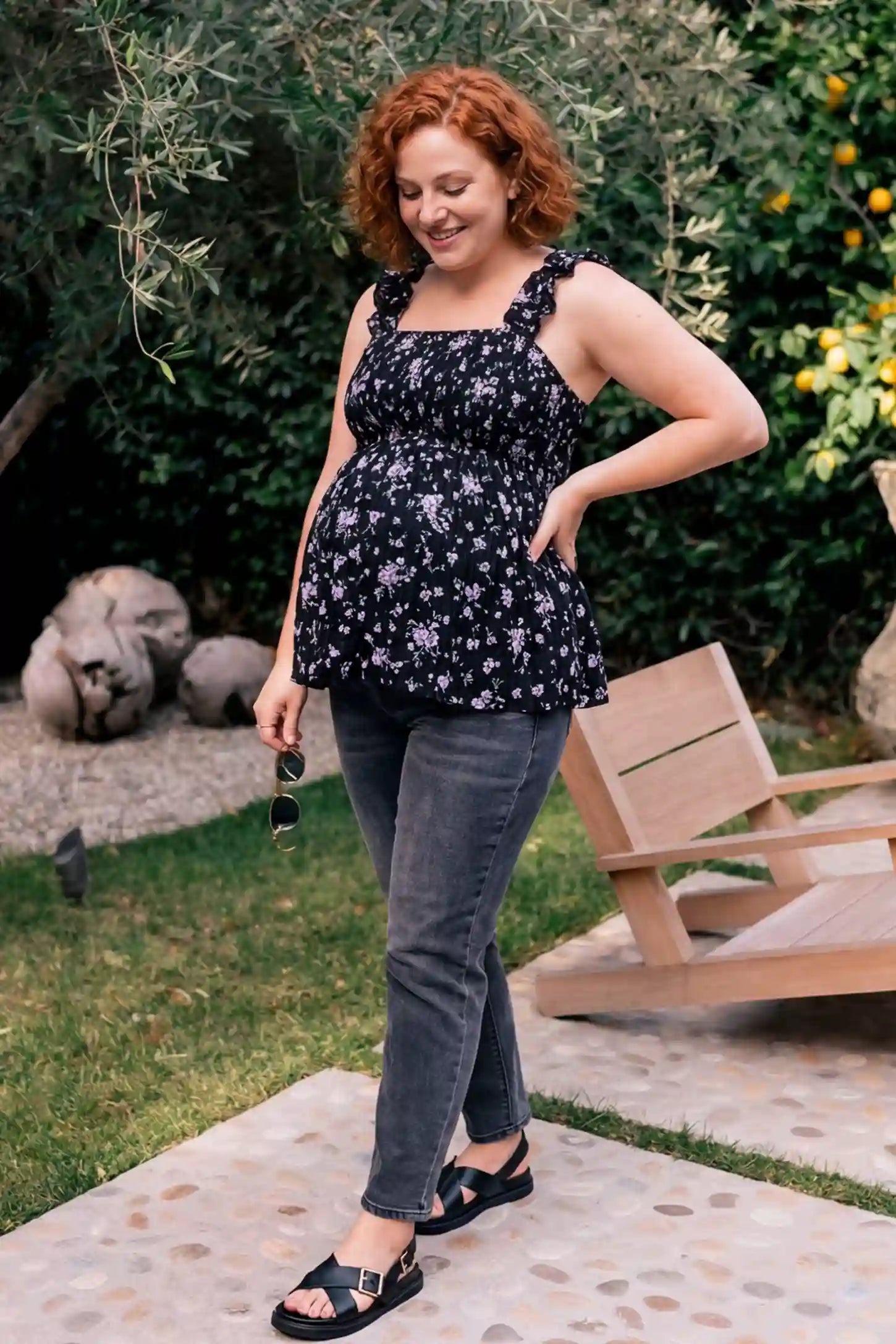Floral Square Neck Babydoll Maternity Top Floral Square Neck Babydoll Maternity Top in Black featuring a smocked bodice and ruffle straps on a pregnant model, editorial lifestyle view.