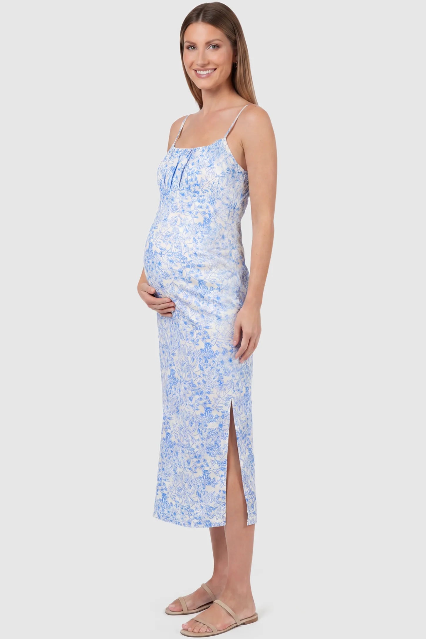 Floral Square Neck Side Ruched Maternity Midi Dress Floral Square Neck Side Ruched Maternity Midi Dress in Blue featuring a botanical print and sleeveless cut on a pregnant model, side view.