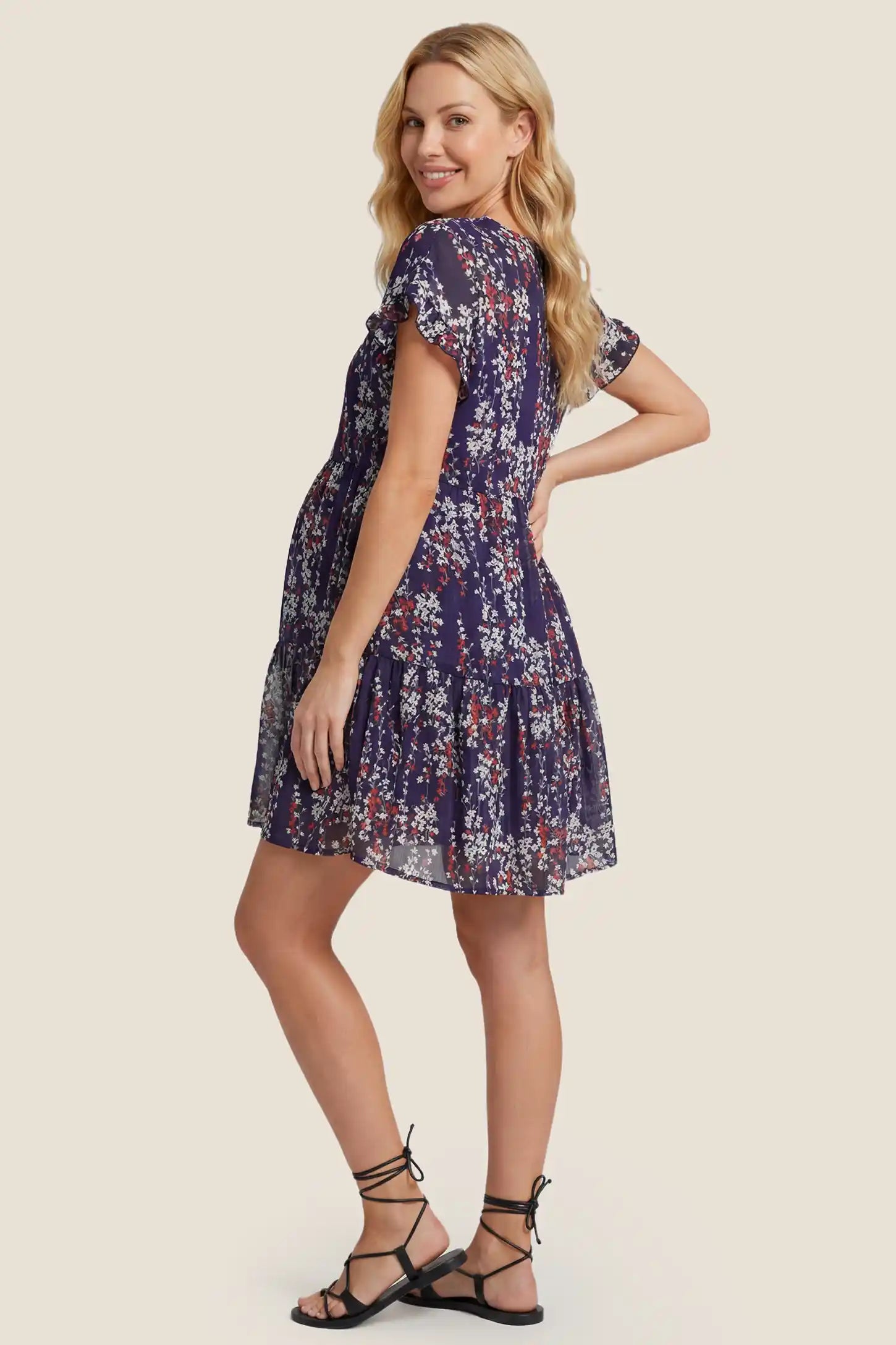 Floral V-Neck A-Line Flutter Sleeve Short Maternity Dress Floral V-Neck A-Line Flutter Sleeve Short Maternity Dress in Navy Blue with an accommodating A-line silhouette, side view on a pregnant model.