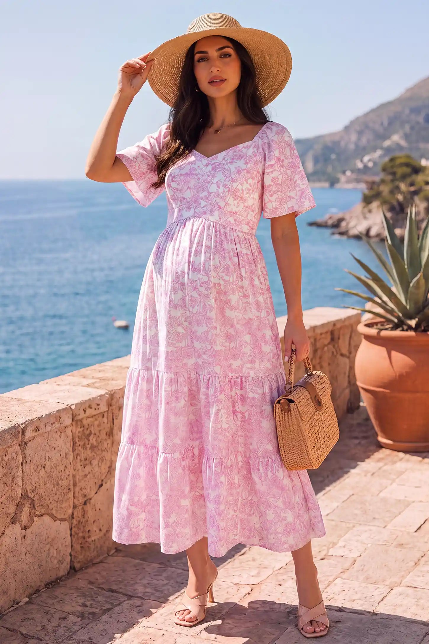 Floral V-Neck Flutter Sleeve Maternity Midi Dress Floral V-Neck Flutter Sleeve Maternity Midi Dress in Pink Floral with a smocked back and tiered skirt, lifestyle view on a pregnant model.