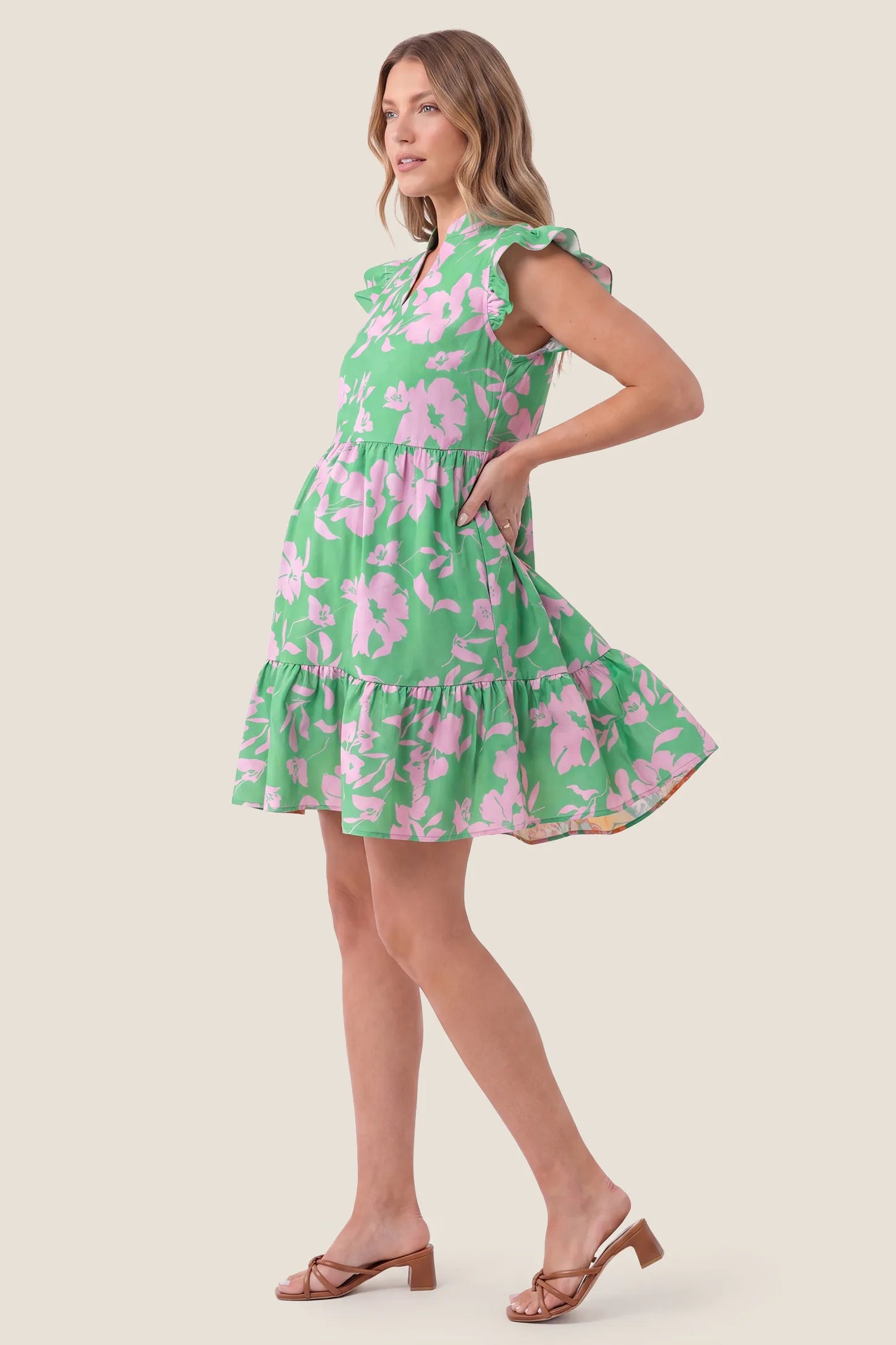 Floral Print V-Neck Flutter Sleeve Maternity Short Dress Floral Print V-Neck Flutter Sleeve Maternity Short Dress in Green showing the A-line flow over the belly, side view on a pregnant model.