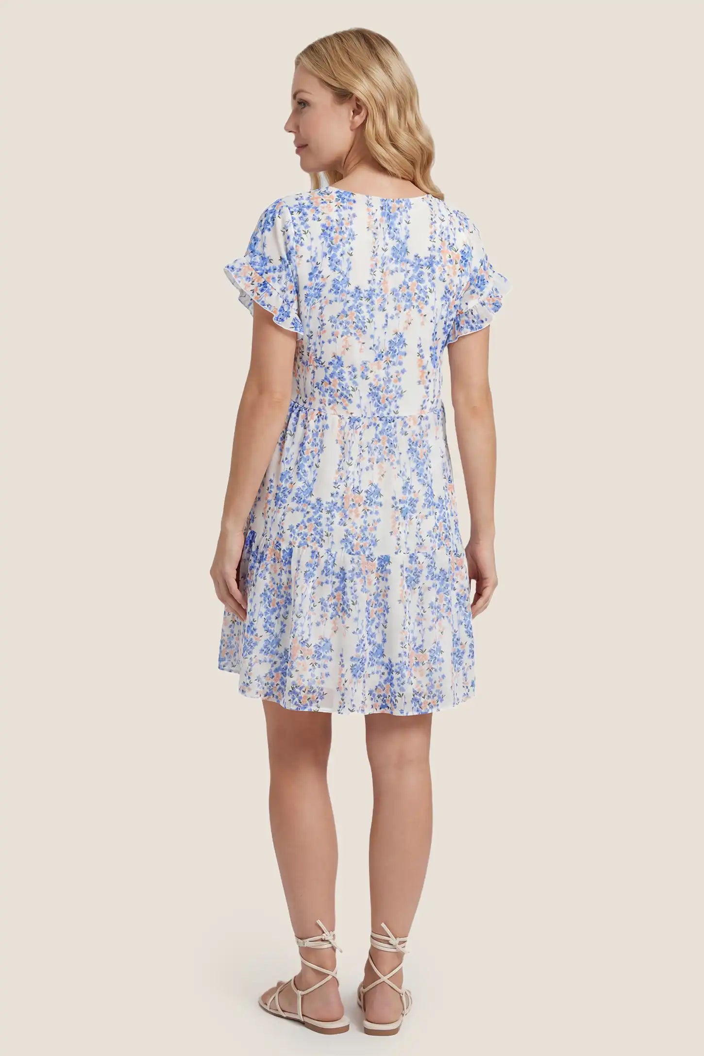 Floral V-Neck A-Line Flutter Sleeve Short Maternity Dress Floral V-Neck Flutter Sleeve Tiered Maternity Mini Dress in White-Blue showcasing the clean back design and flowing tiered structure, back view on a pregnant model.