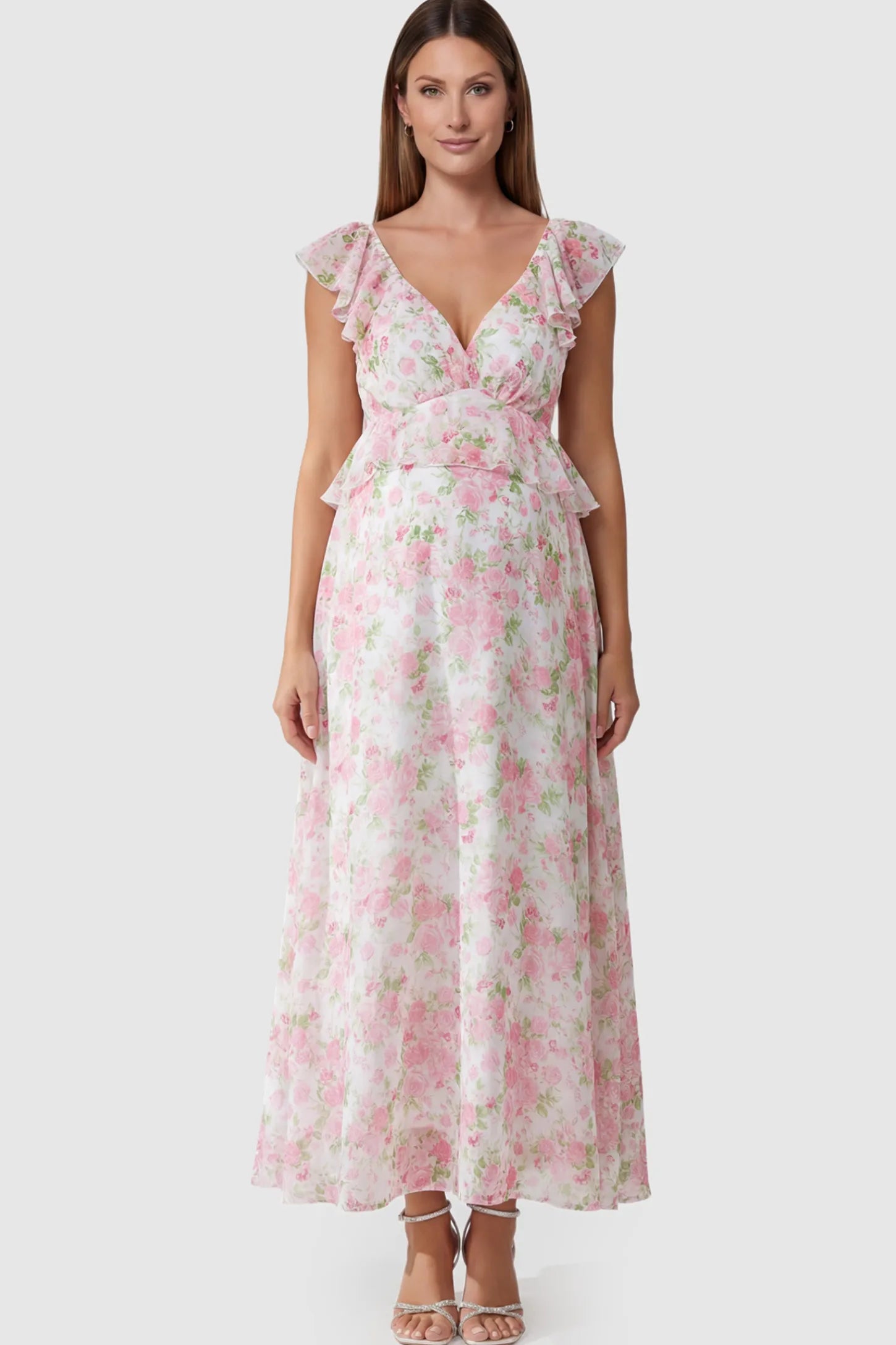 Floral Print V-Neck Ruffle Backless Maxi Maternity Dress with a peplum waist and flutter sleeves on a pregnant model showing front.