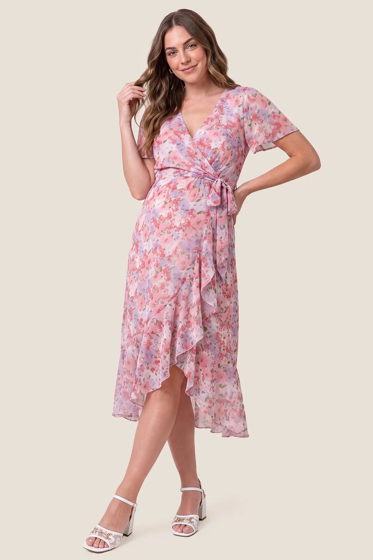 Floral V-Neck Ruffled Hem Midi Maternity Dress Floral V-Neck Ruffled Hem Midi Maternity Dress in Pink featuring a floral print, V-neckline, and ruffled hemline, front view on a pregnant model.