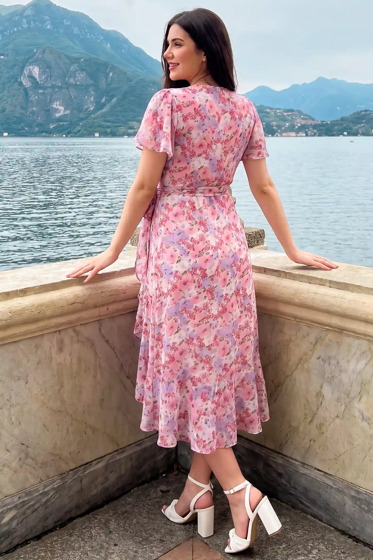 Floral V-Neck Ruffled Hem Midi Maternity Dress Floral V-Neck Ruffled Hem Midi Maternity Dress in Pink with a charming floral pattern and ruffled hem, lifestyle back view on a pregnant model.