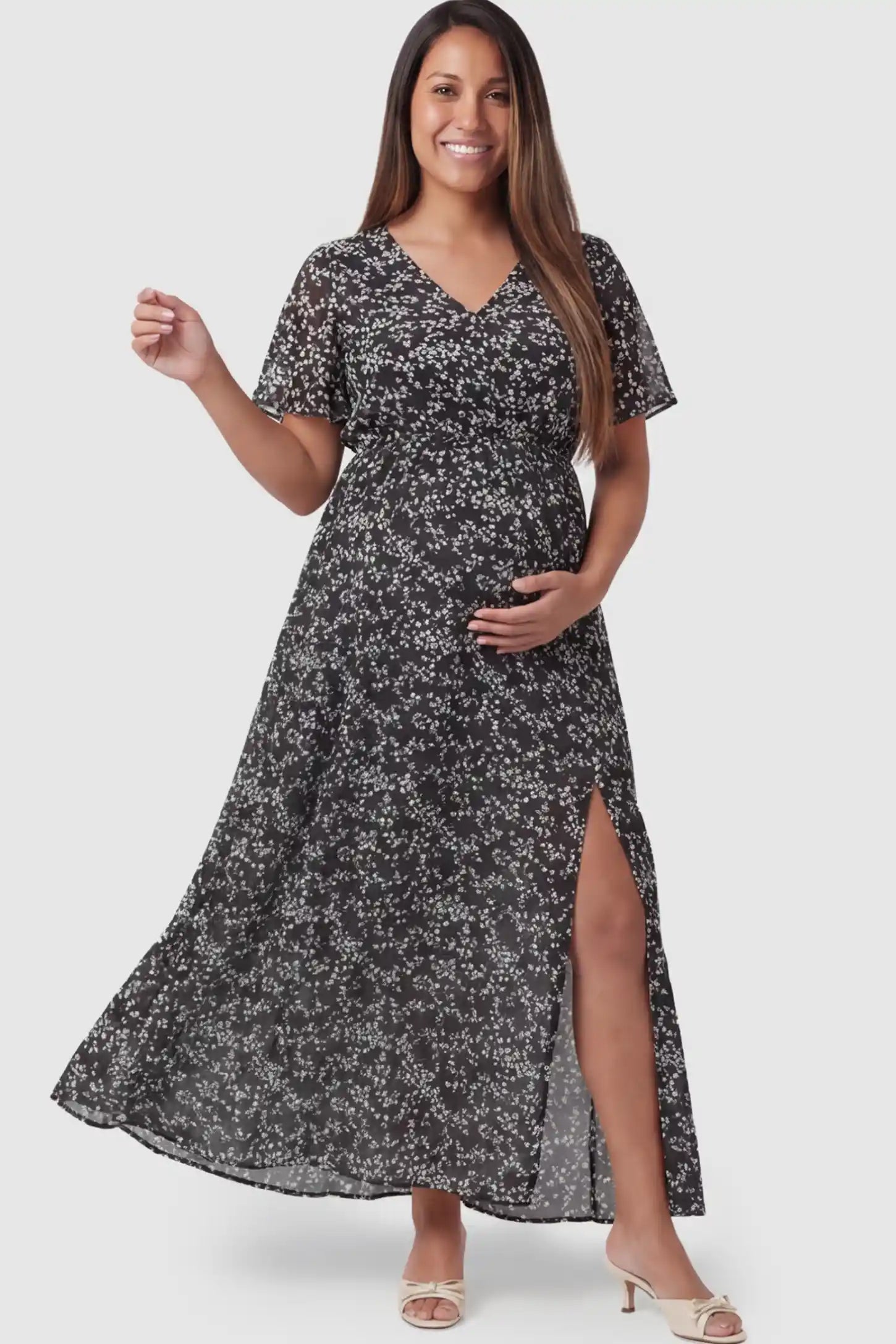 Floral V-Neck Side-Slit Maternity Maxi Dress in black featuring slit on a pregnant model posing front.