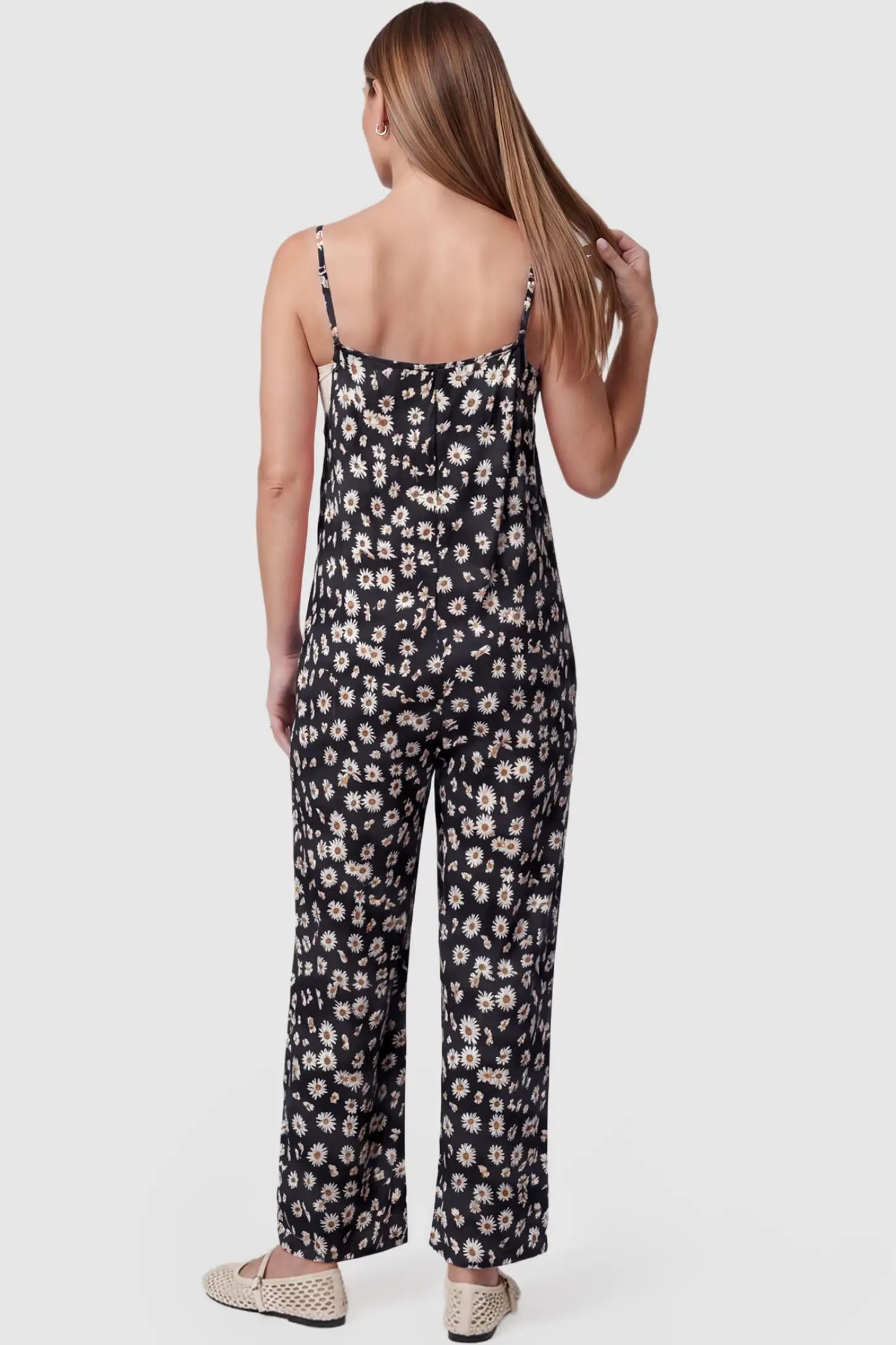 Floral Wide-Leg Pocket Maternity Jumpsuit Floral Wide-Leg Pocket Jumpsuit in Black featuring an all-over daisy print on a non-pregnant model, back view.