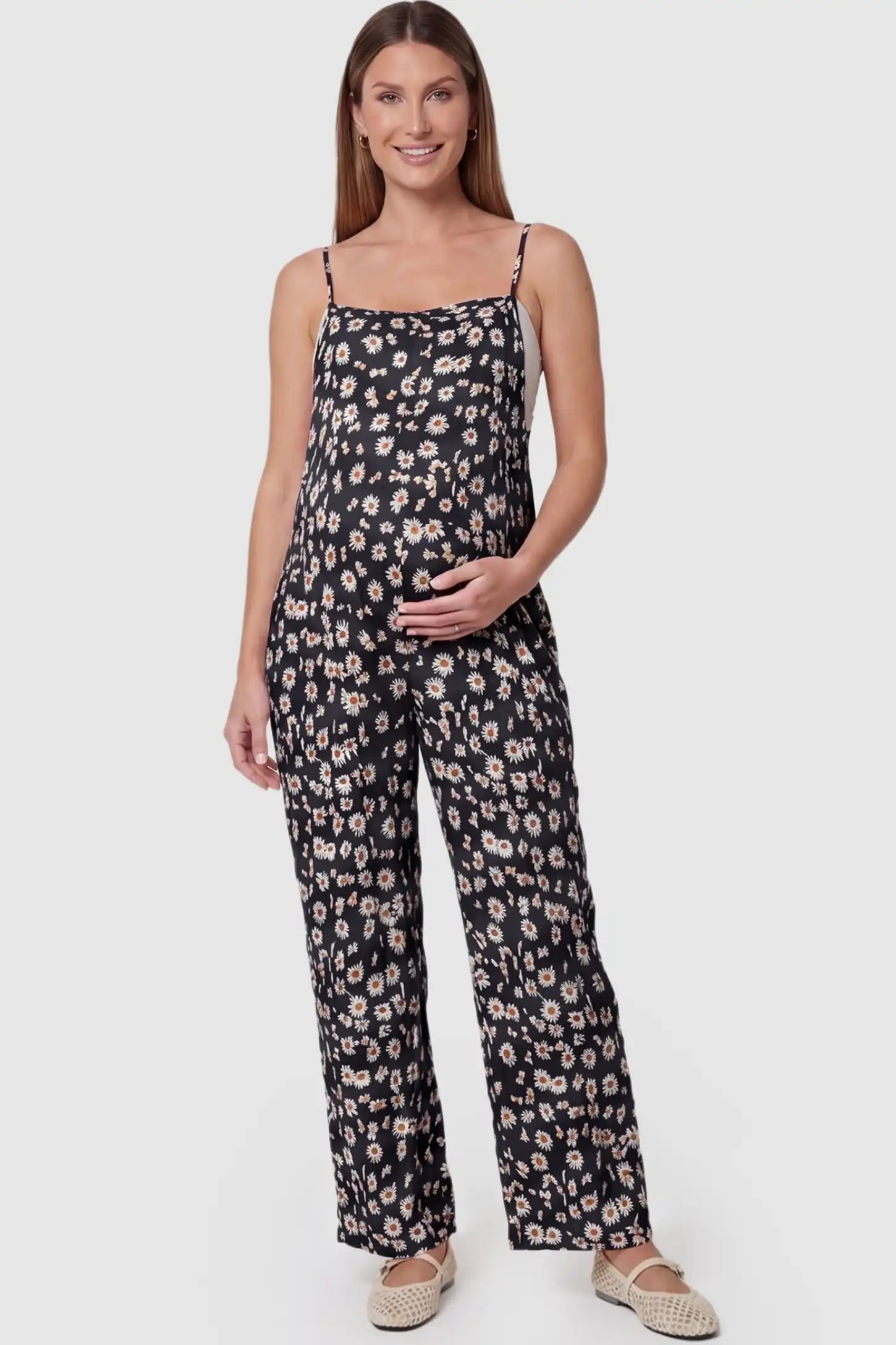 Floral Wide-Leg Pocket Maternity Jumpsuit Floral Wide-Leg Pocket Jumpsuit in Black featuring an all-over daisy print on a pregnant model, front view.