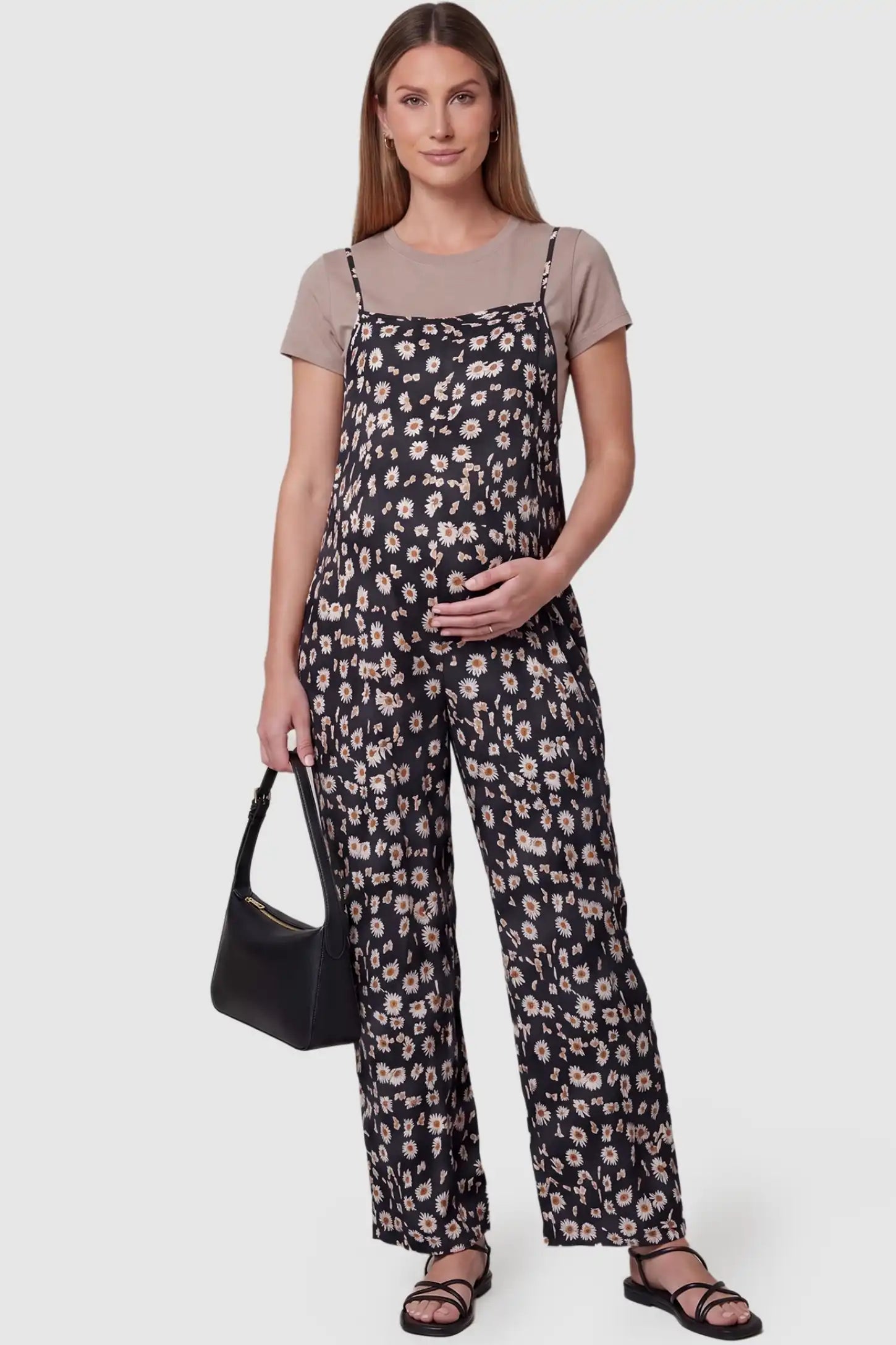 Floral Wide-Leg Pocket Maternity Jumpsuit Floral Wide-Leg Pocket Jumpsuit in Black featuring an all-over daisy print on a pregnant model, front view.